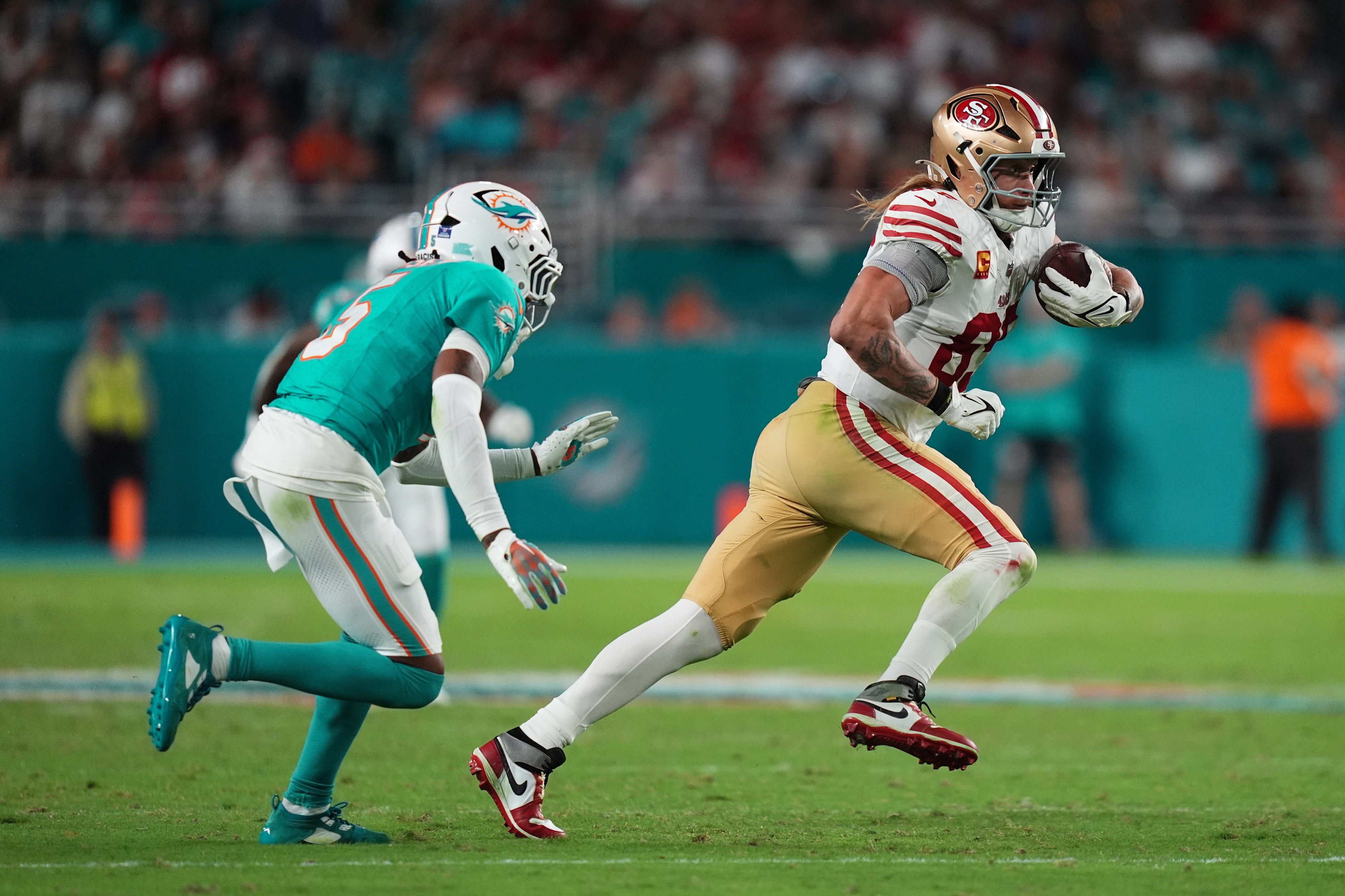 San Francisco 49ers tight end George Kittle (85) runs with the ball after a catch against the Miami Dolphins during second half at Hard Rock Stadium.