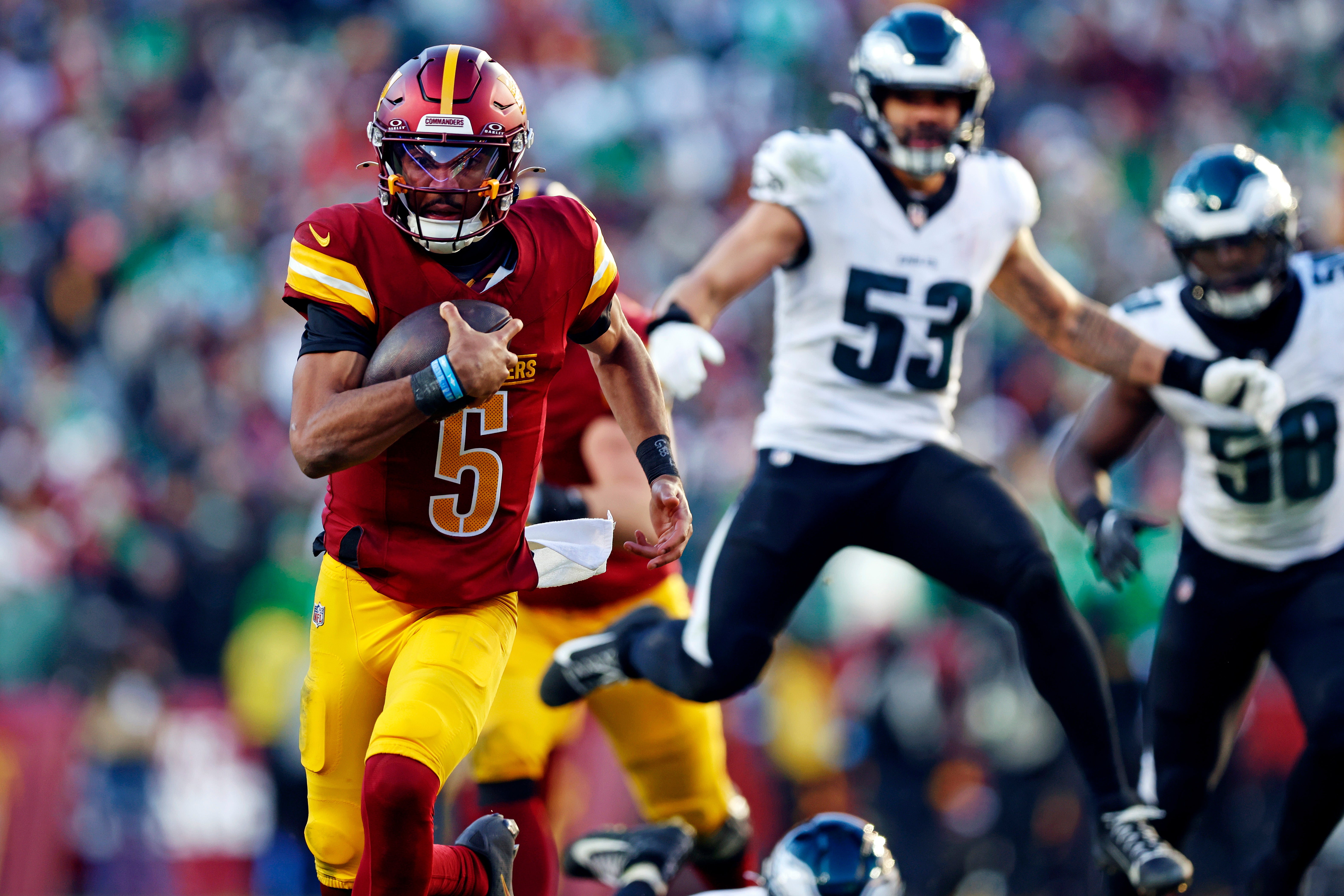 Dec 22, 2024; Landover, Maryland, USA; Washington Commanders quarterback Jayden Daniels (5) runs the ball against the Philadelphia Eagles during the third quarter at Northwest Stadium.