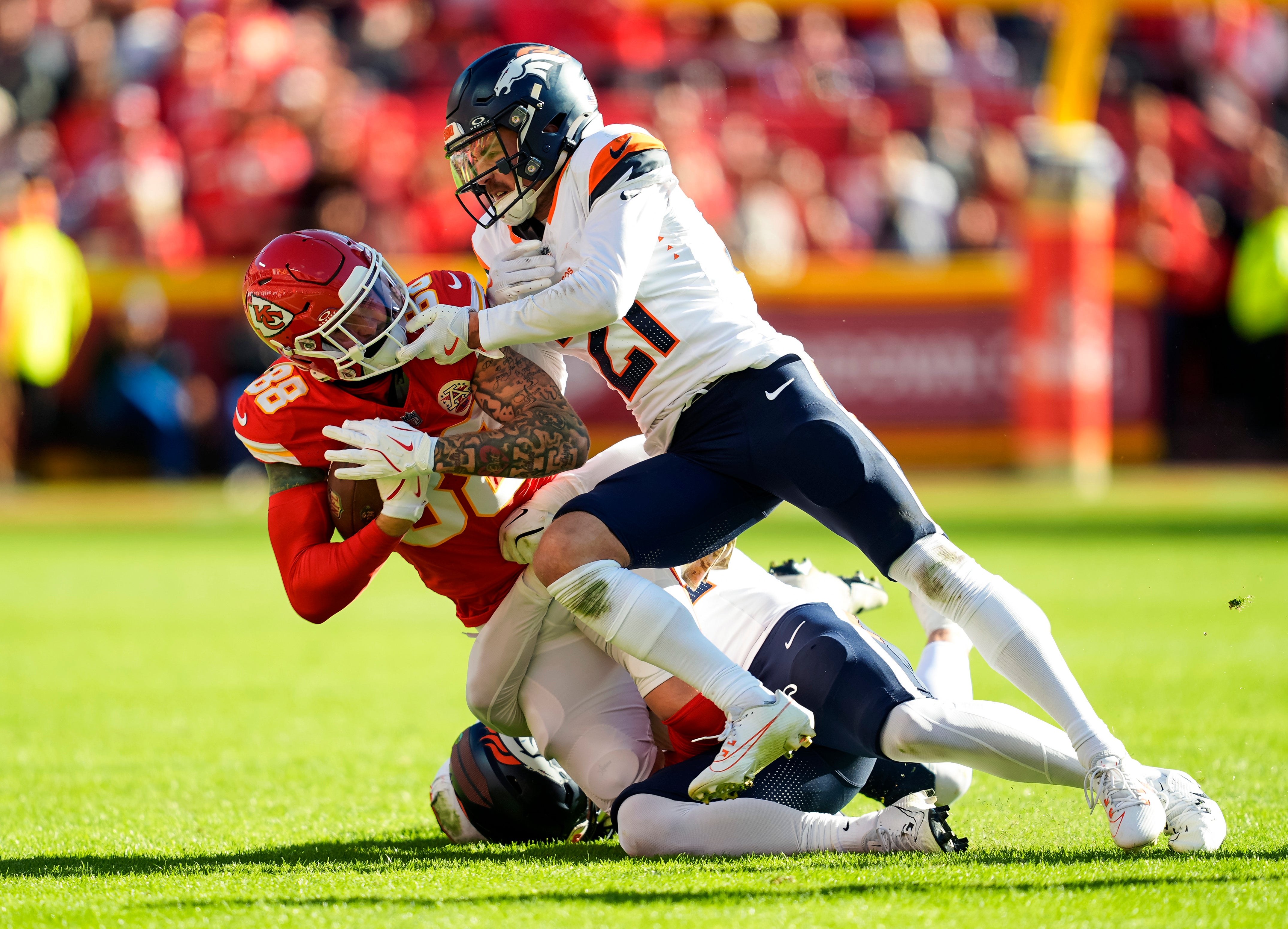 Nov 10, 2024; Kansas City, Missouri, USA; Kansas City Chiefs tight end Peyton Hendershot (88) is tackled by Denver Broncos cornerback Riley Moss (21) during the second half at GEHA Field at Arrowhead Stadium.