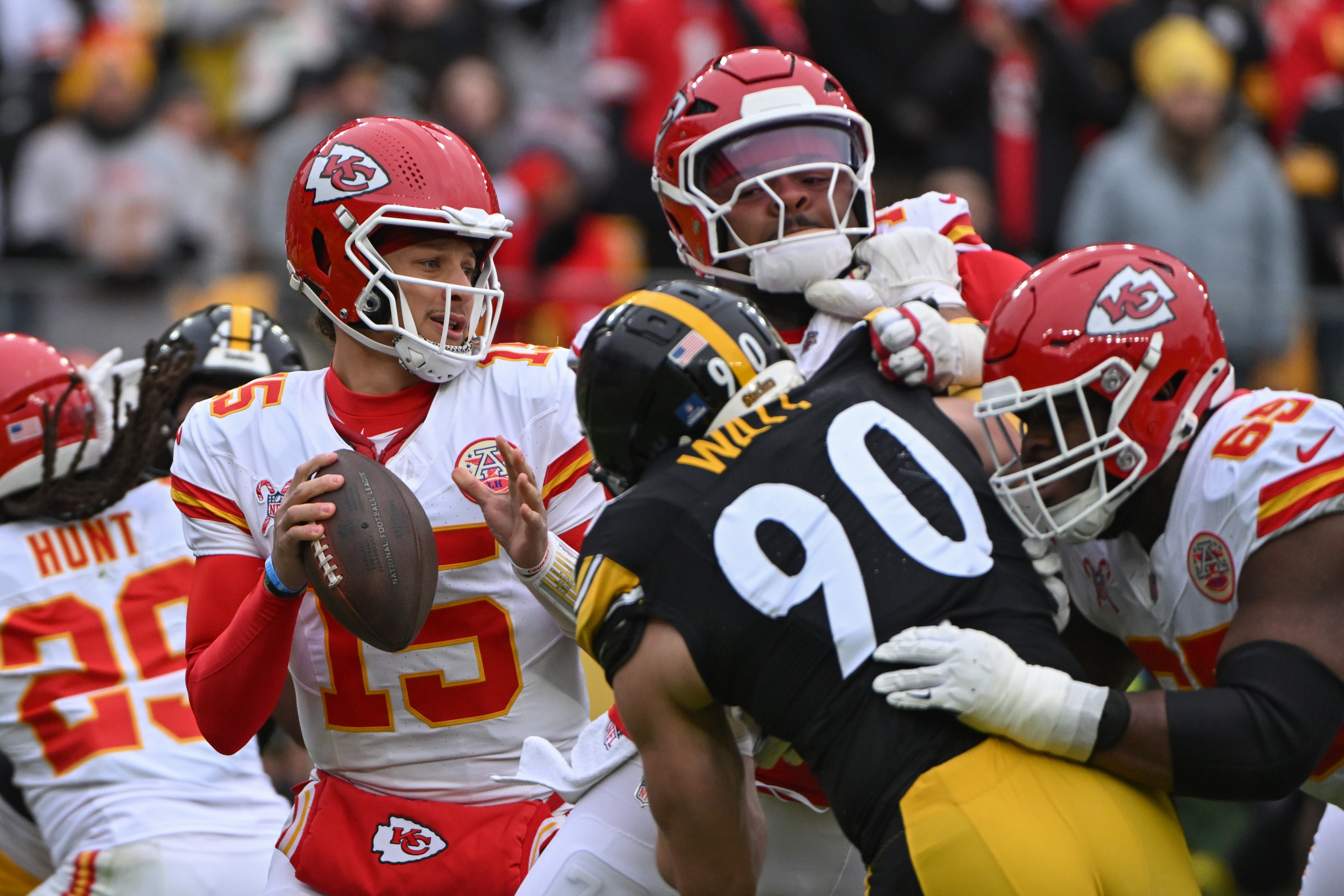 Chiefs quarterback Patrick Mahomes (15) looks to pass while being pressured by Steelers linebacker T.J. Watt