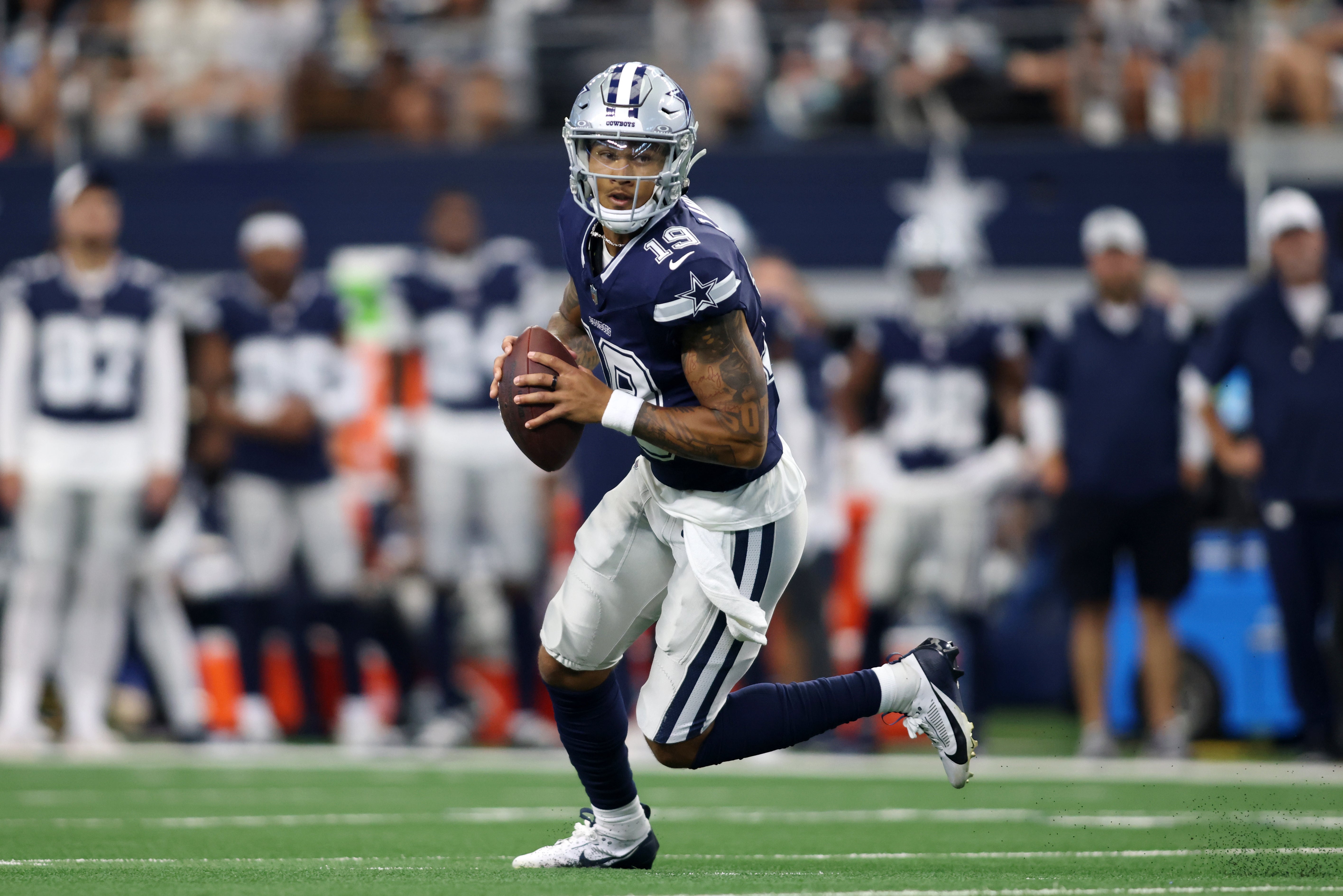Dallas Cowboys quarterback Trey Lance (19) rolls out to pass against the Los Angeles Chargers in the first quarter at AT&T Stadium.