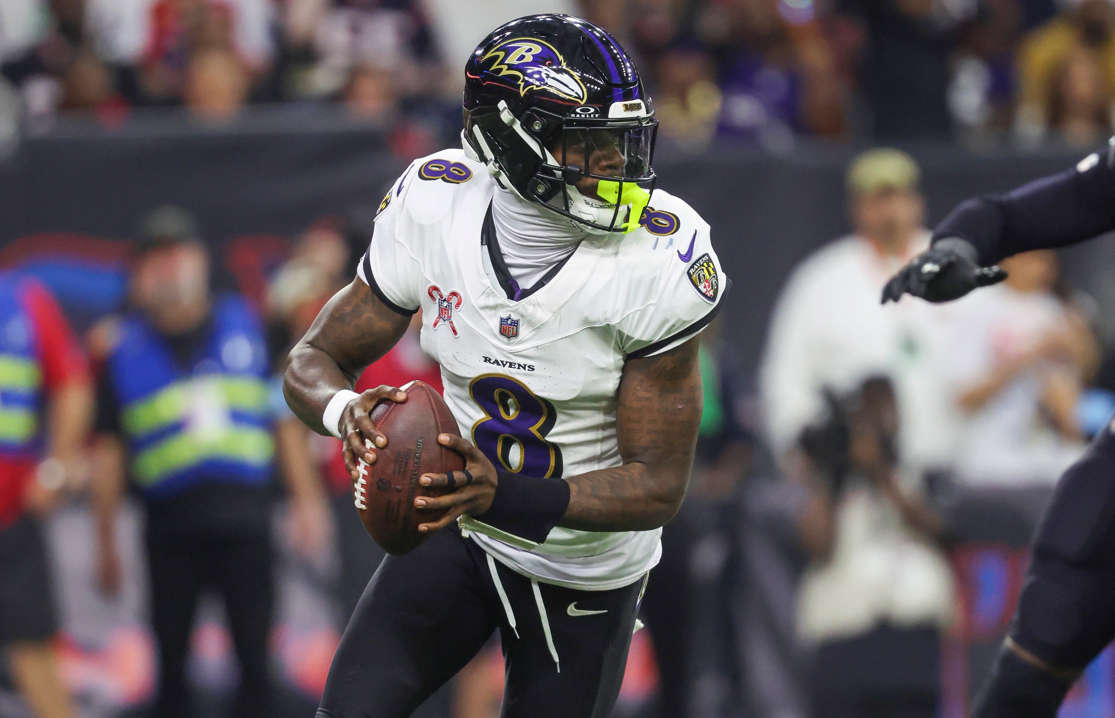 Dec 25, 2024; Houston, Texas, USA; Baltimore Ravens quarterback Lamar Jackson (8) rolls out of the pocket with the ball during the game against the Houston Texans at NRG Stadium.