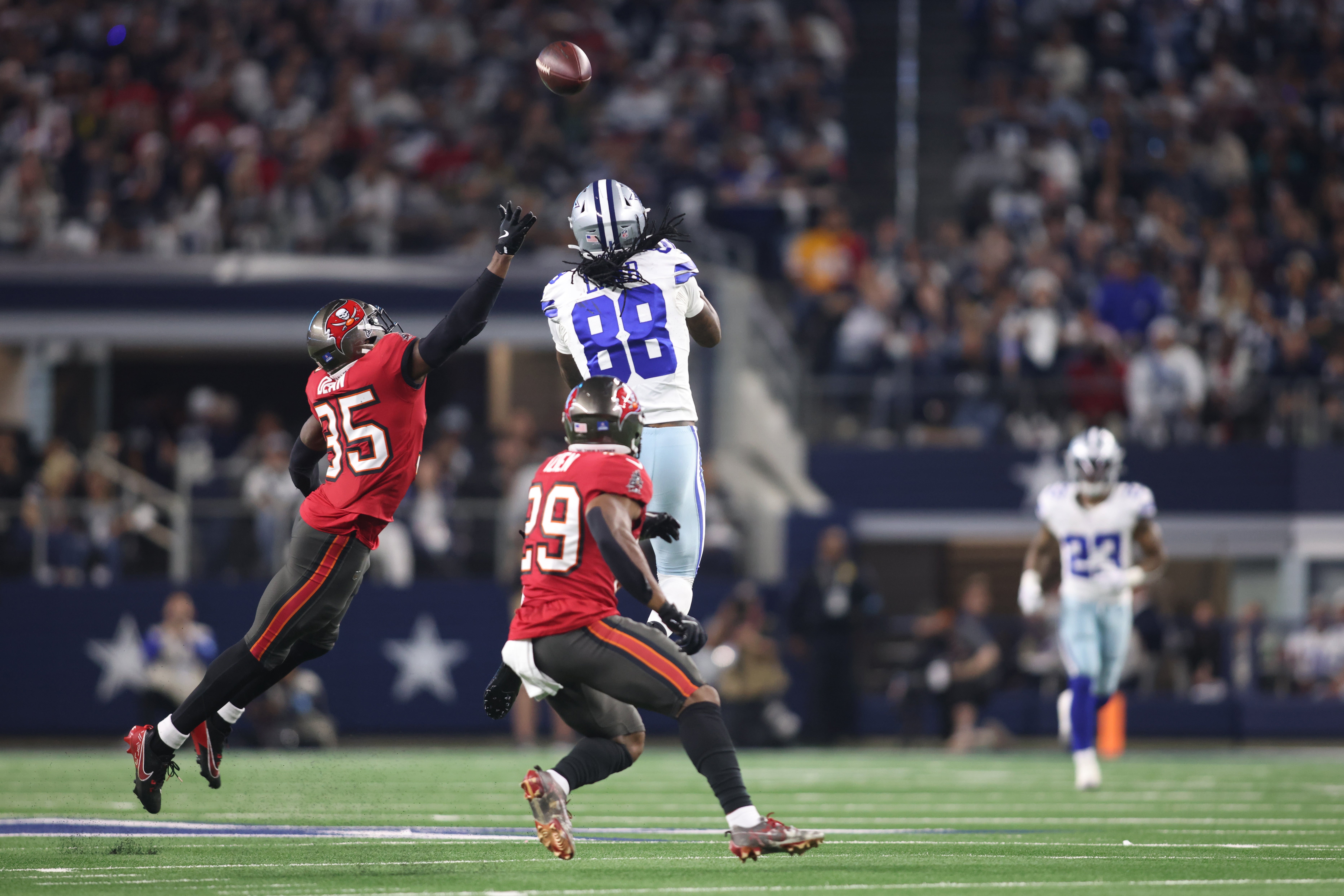 Dec 22, 2024; Arlington, Texas, USA; Dallas Cowboys wide receiver CeeDee Lamb (88) catches a pass against Tampa Bay Buccaneers cornerback Jamel Dean (35) and safety Christian Izien (29) in the second quarter at AT&T Stadium.