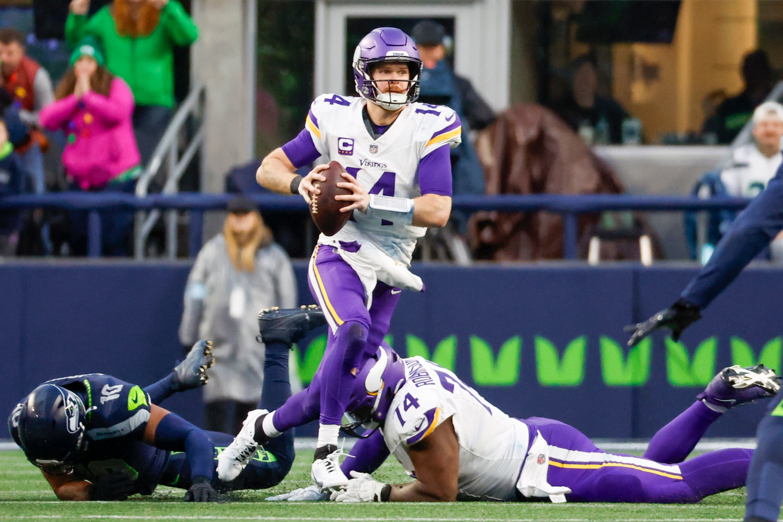 Dec 22, 2024; Seattle, Washington, USA; Minnesota Vikings quarterback Sam Darnold (14) scrambles out of the pocket against the Seattle Seahawks during the fourth quarter at Lumen Field.