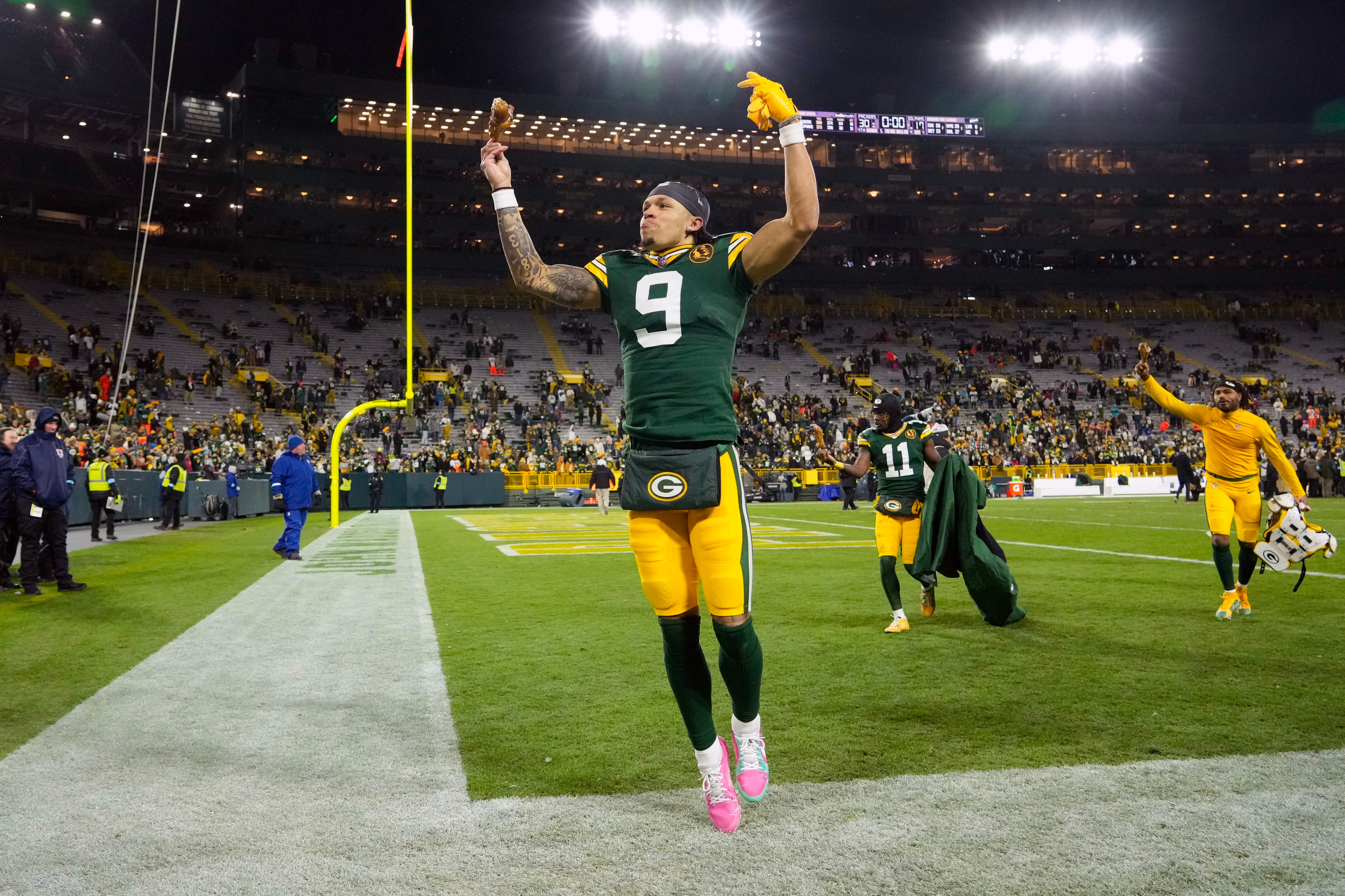 Green Bay Packers wide receiver Christian Watson (9) celebrates while holding a turkey leg on his way off the field following the game against the Miami Dolphins at Lambeau Field.