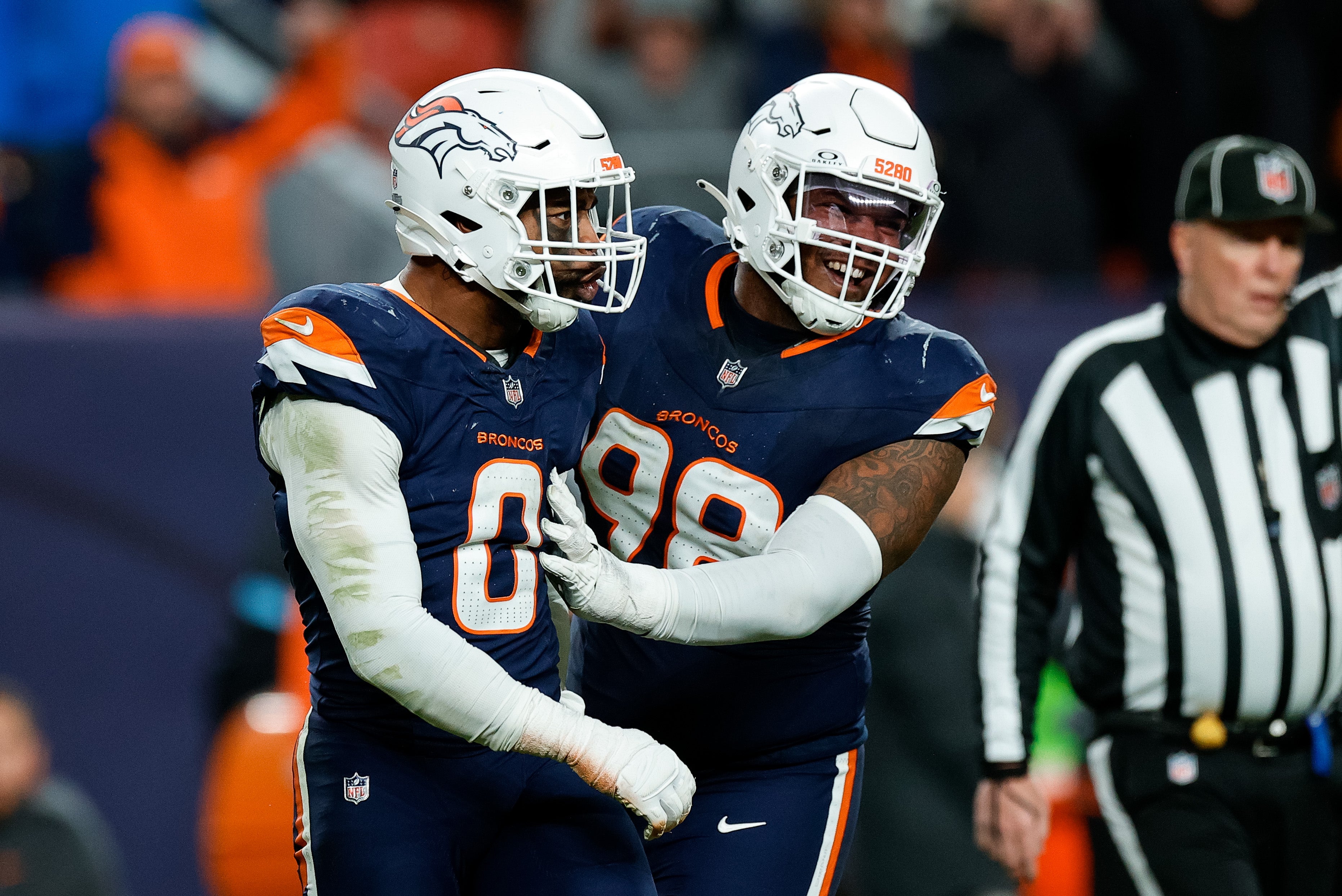 Dec 2, 2024; Denver, Colorado, USA; Denver Broncos linebacker Jonathon Cooper (0) reacts with defensive end John Franklin-Myers (98) after a play in the fourth quarter against the Cleveland Browns at Empower Field at Mile High.
