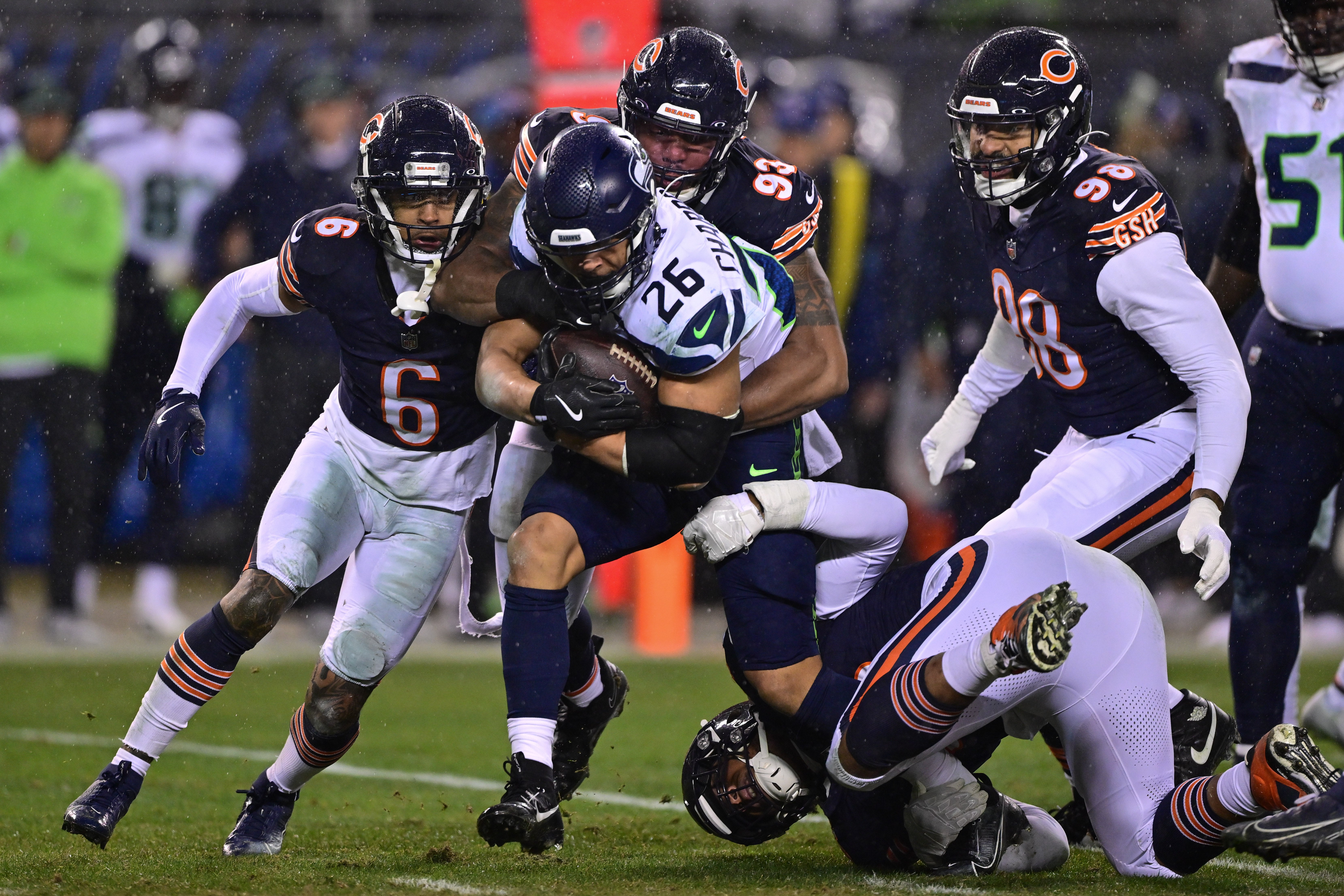 Dec 26, 2024; Chicago, Illinois, USA; Seattle Seahawks running back Zach Charbonnet (26) is tackled after a run against the Chicago Bears during the third quarter at Soldier Field.