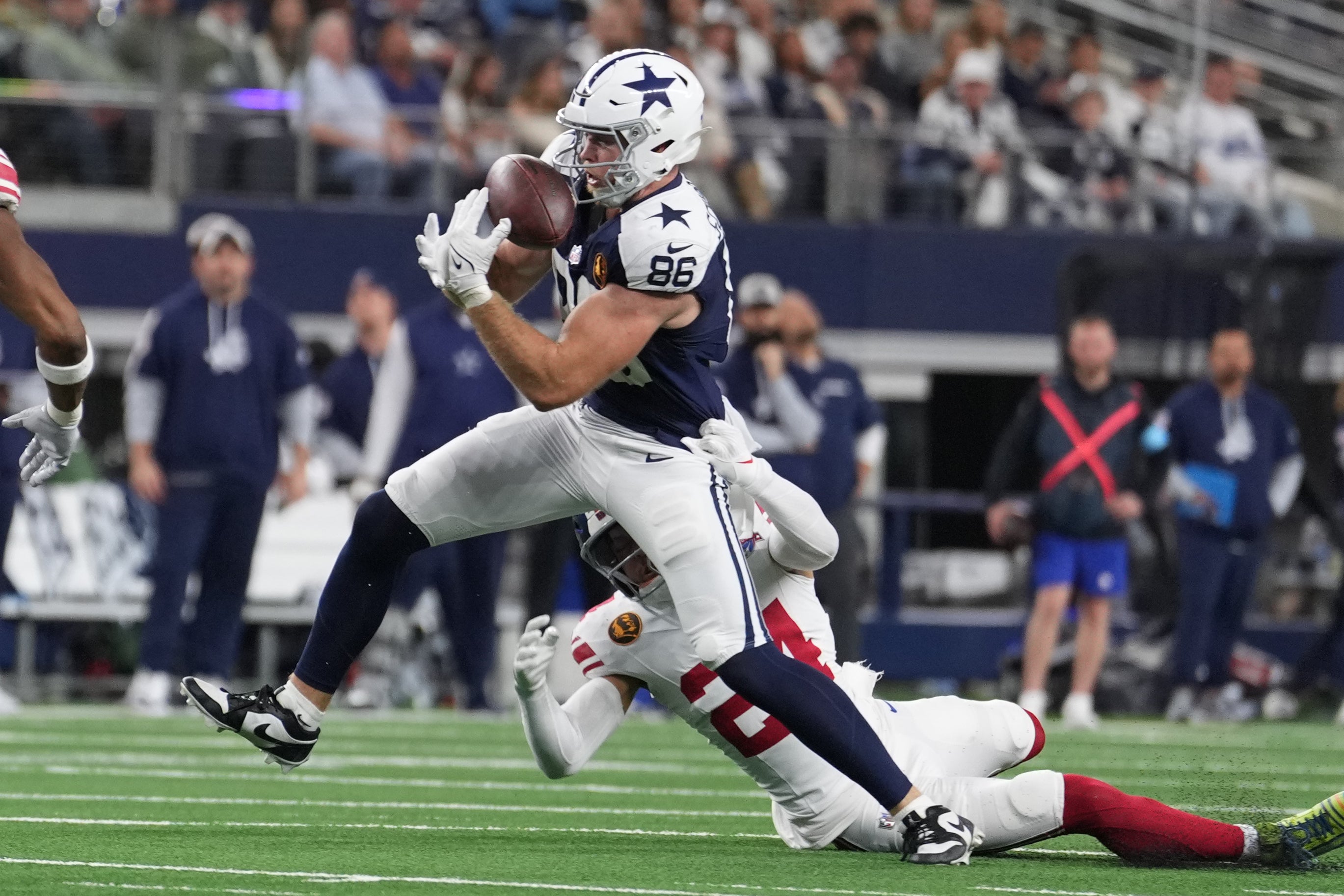 Dallas Cowboys tight end Luke Schoonmaker (86) catches a pass as New York Giants safety Dane Belton (24) defends during the first half at AT&T Stadium.