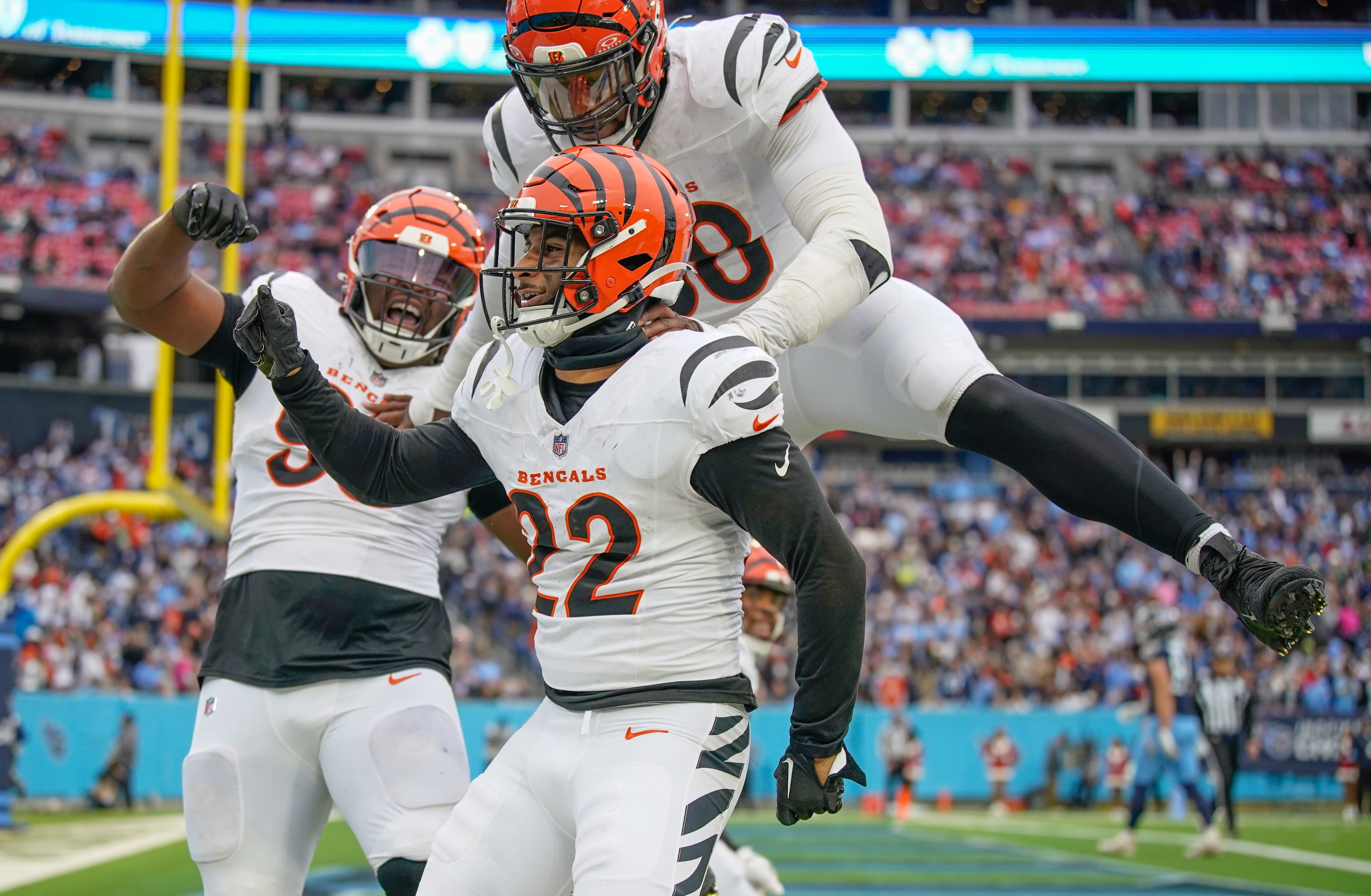 Cincinnati Bengals safety Geno Stone (22) celebrates his touchdown off of an interception against the Tennessee Titans during the third quarter at Nissan Stadium in Nashville, Tenn., Sunday, Dec. 15, 2024. Defensive tackle McKinnley Jackson (93) and defensive end Joseph Ossai (58) join in.