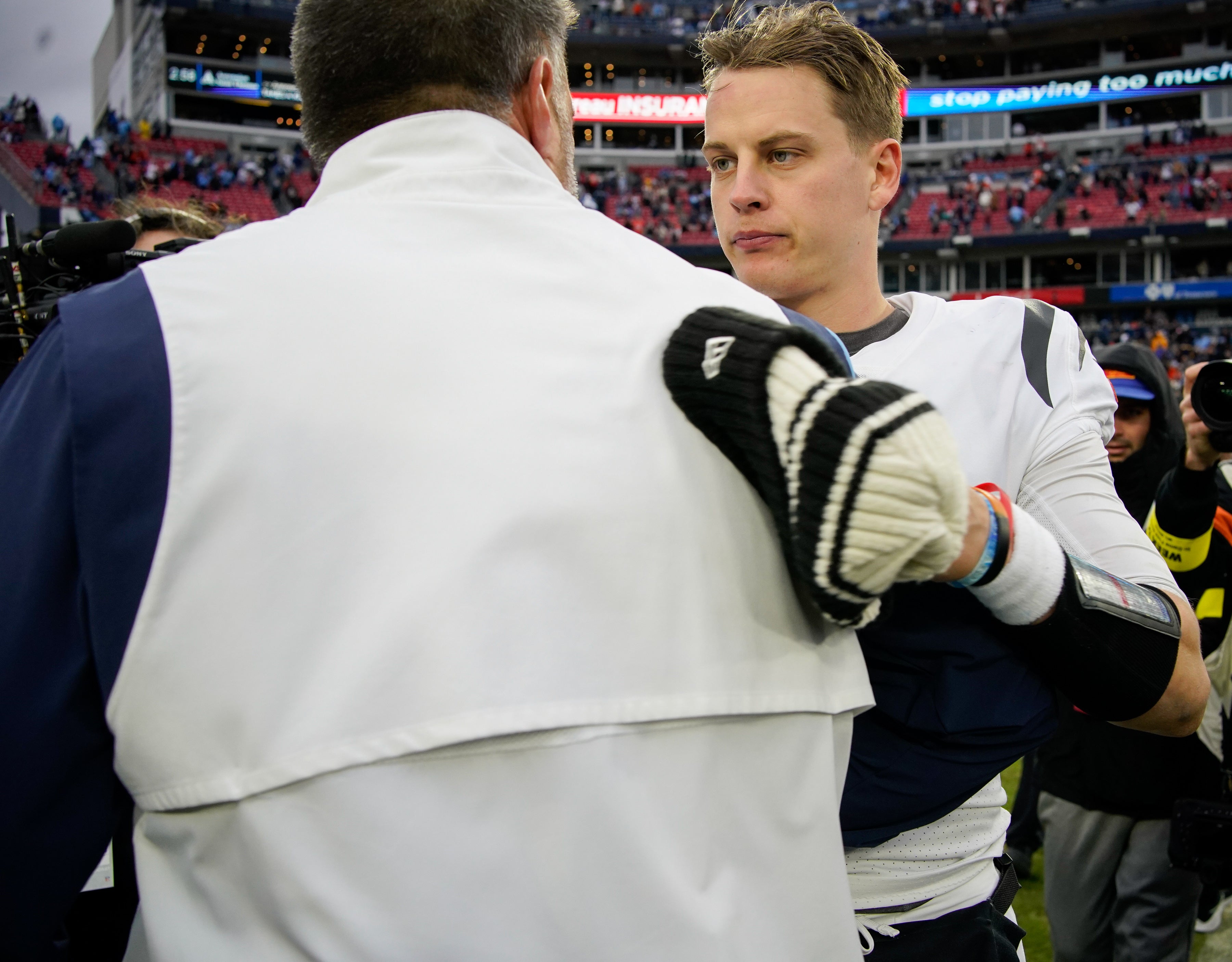 Nov 27, 2022; Nashville, Tennessee, USA; Cincinnati Bengals quarterback Joe Burrow (9) talks to Tennessee Titans head coach Mike Vrabel after beating the Tennessee Titans at Nissan Stadium. Mandatory Credit: George Walker IV-Imagn Images