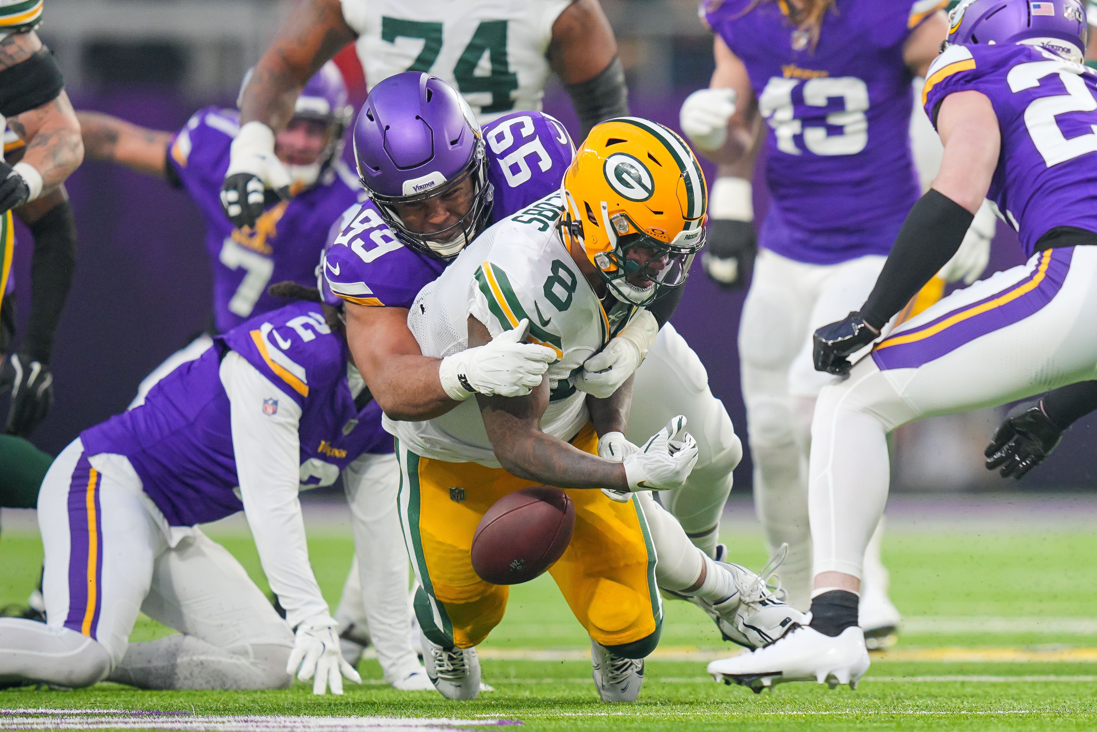 Green Bay Packers running back Josh Jacobs (8) fumbles against Minnesota Vikings defensive tackle Jerry Tillery (99) in the first quarter at U.S. Bank Stadium.