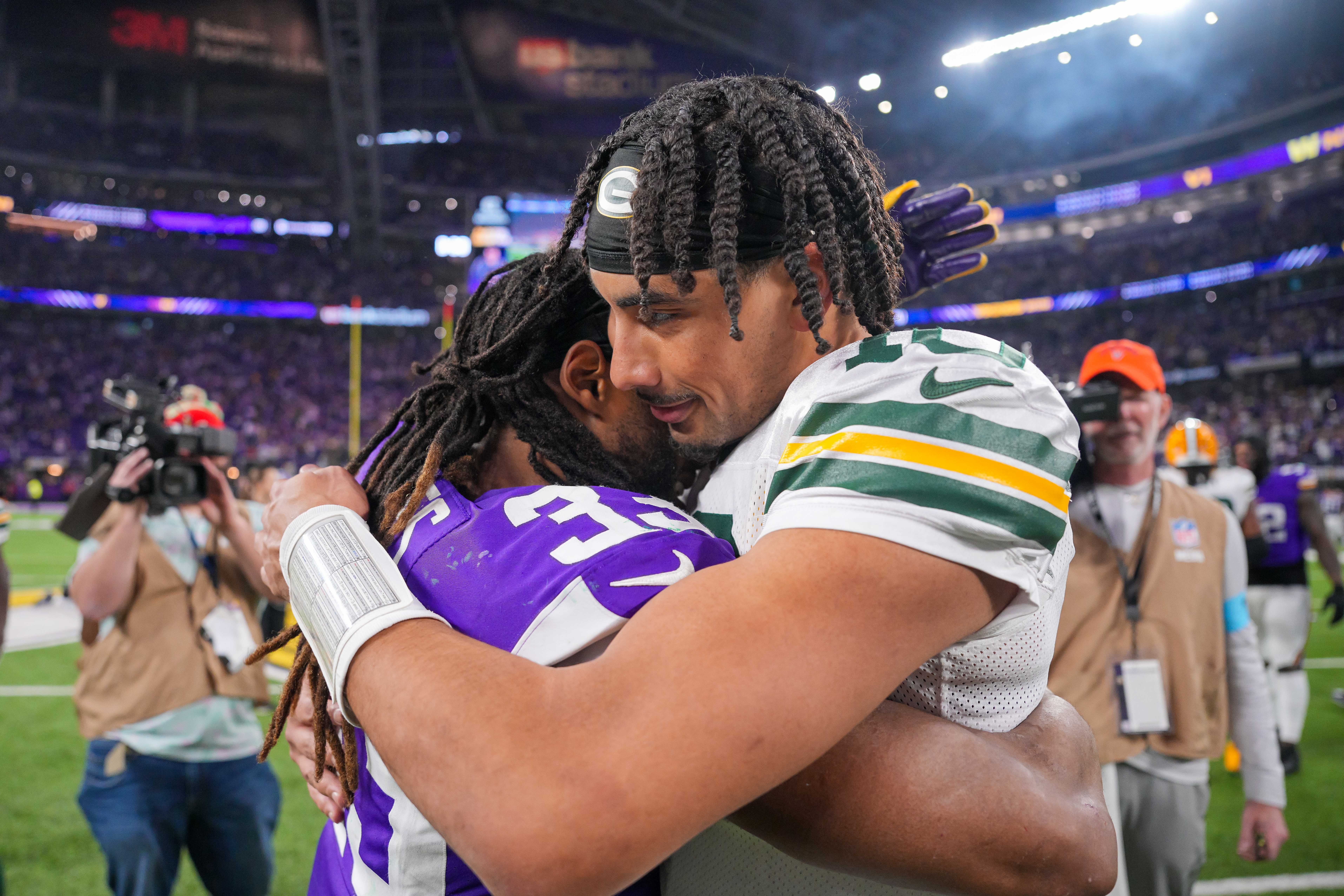 Green Bay Packers quarterback Jordan Love (10) and Minnesota Vikings running back Aaron Jones (33) hug after the game at U.S. Bank Stadium.