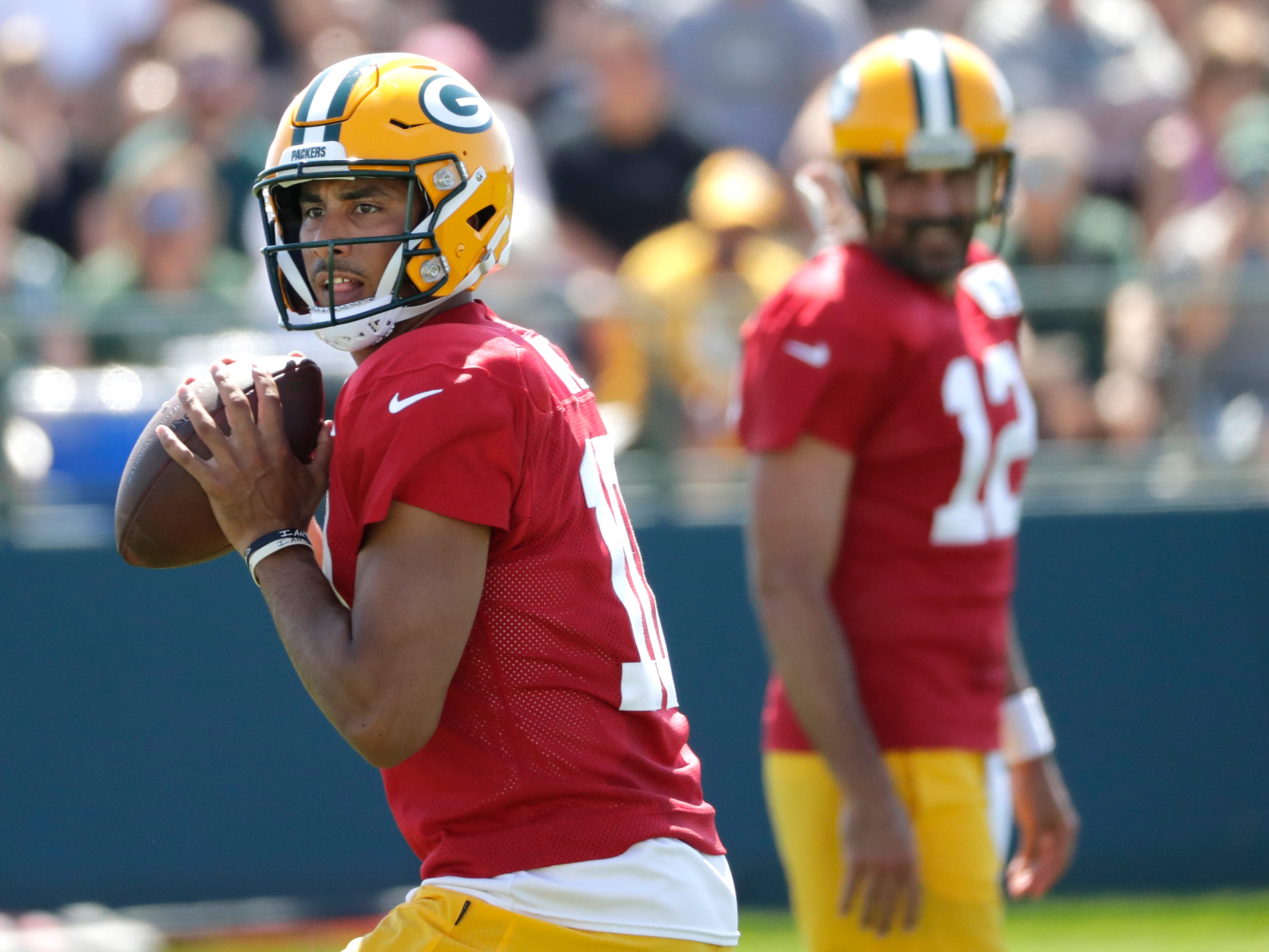 Green Bay Packers quarterback Jordan Love (10) passes as Aaron Rodgers looks on during training camp Wednesday, August 10, 2022, at Ray Nitschke Field in Green Bay, Wis.