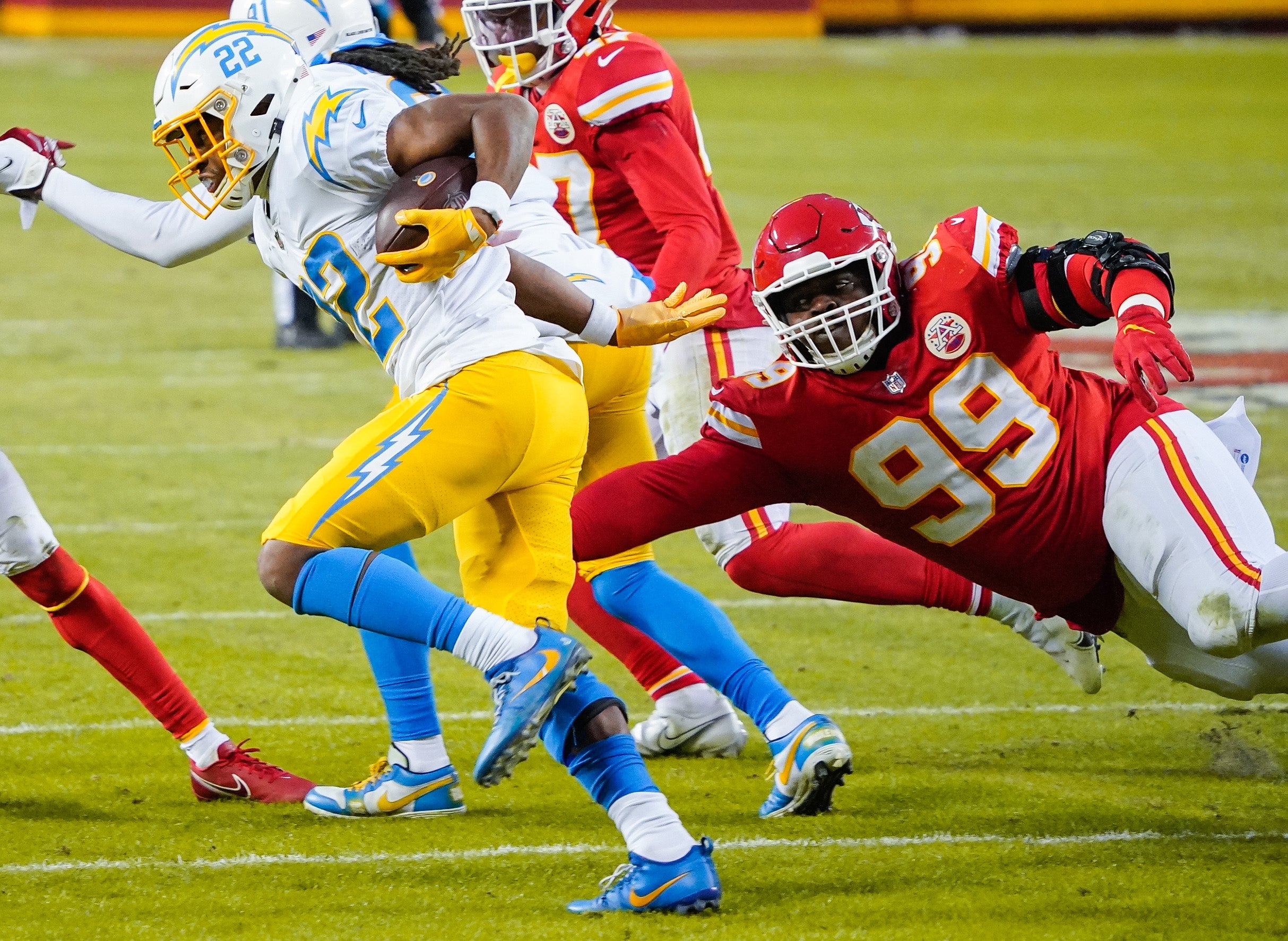 Jan 3, 2021; Kansas City, Missouri, USA; Los Angeles Chargers running back Justin Jackson (22) runs the ball against Kansas City Chiefs defensive tackle Khalen Saunders (99) during the first half at Arrowhead Stadium.