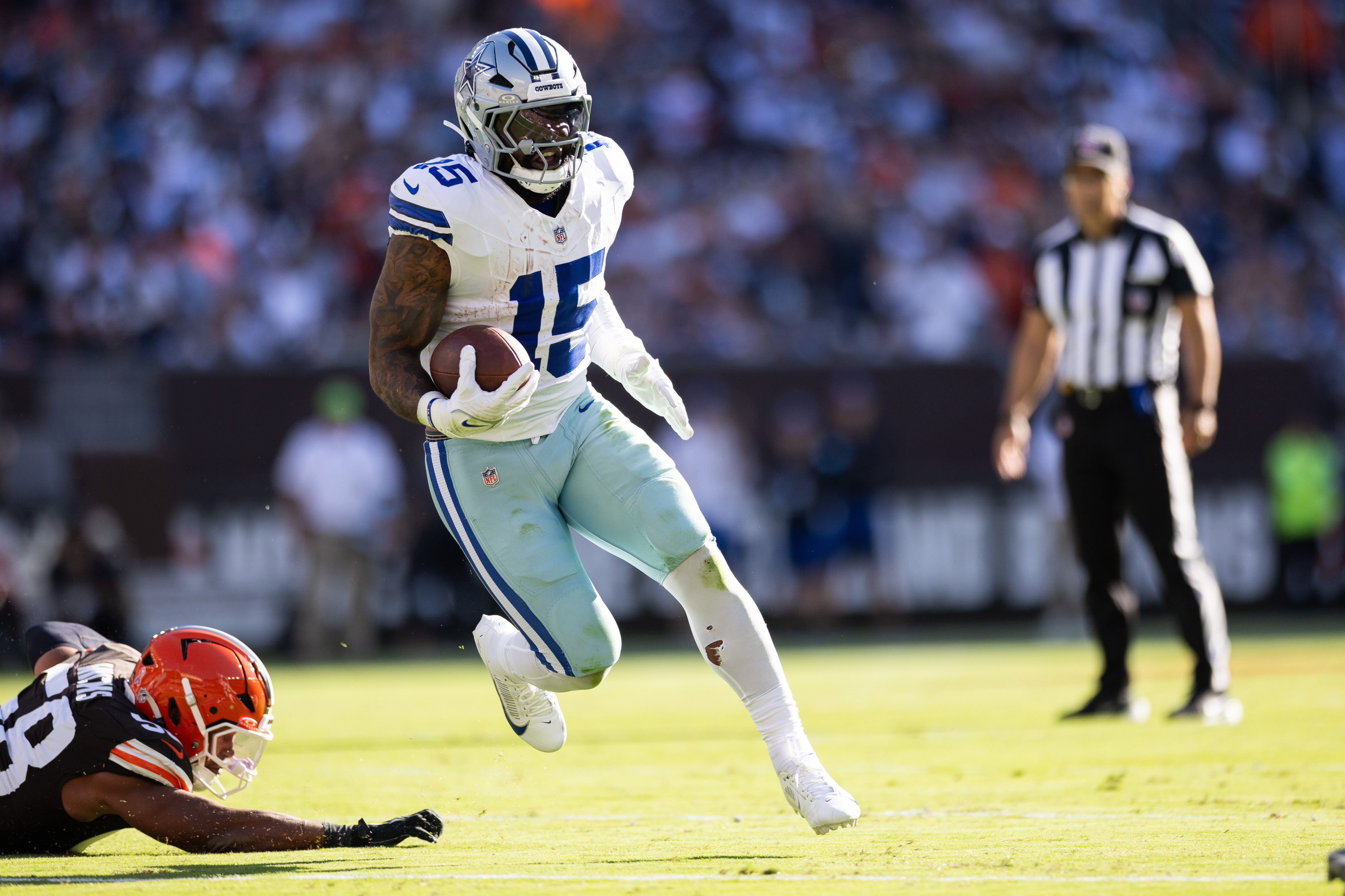 Dallas Cowboys running back Ezekiel Elliott (15) runs the ball against the Cleveland Browns during the second quarter at Huntington Bank Field.