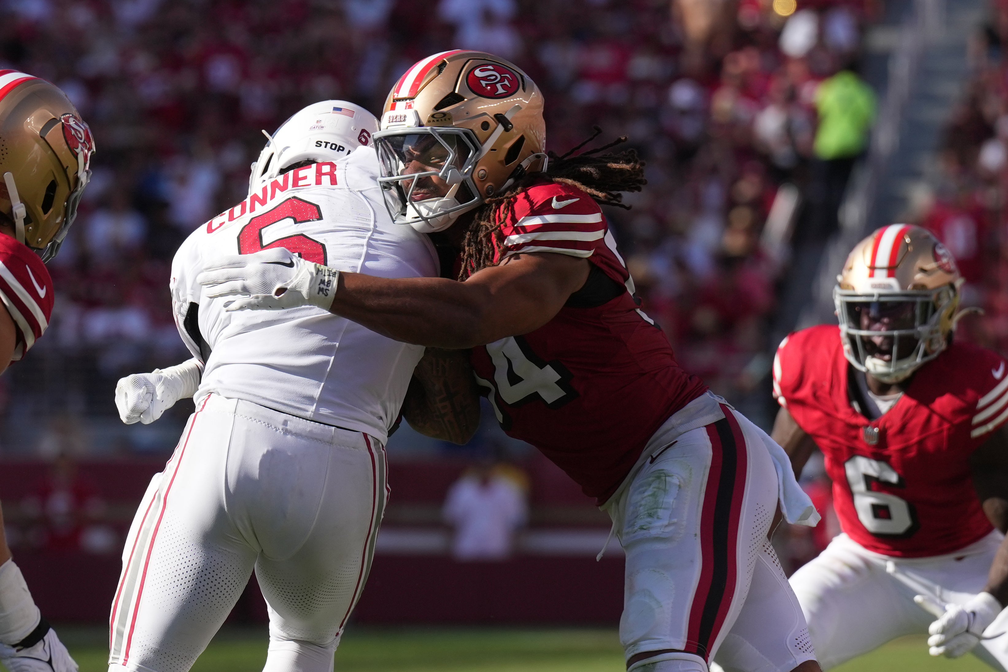 San Francisco 49ers linebacker Fred Warner (center right) tackles Arizona Cardinals running back James Conner (center left) during the fourth quarter at Levi's Stadium.