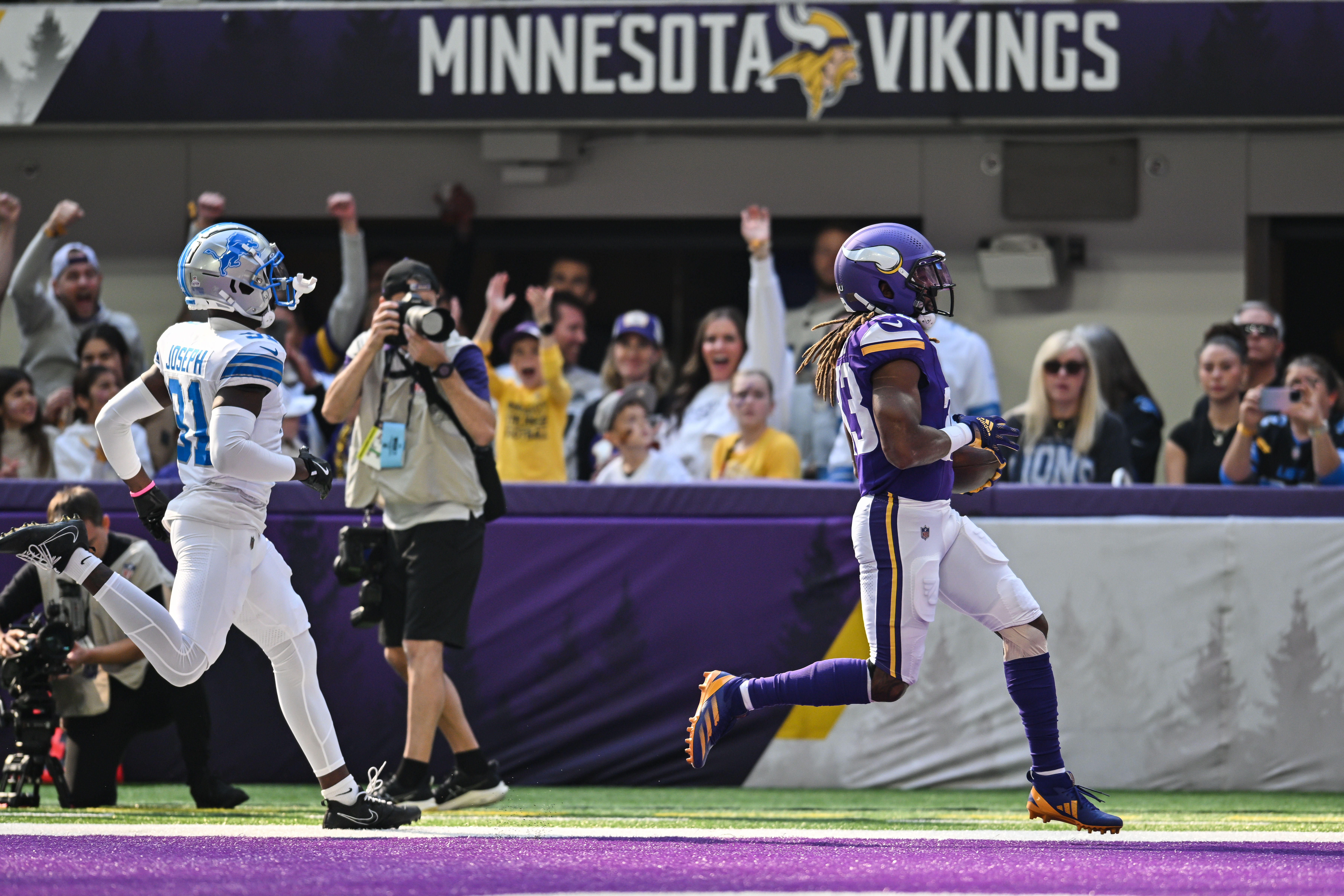 Oct 20, 2024; Minneapolis, Minnesota, USA; Minnesota Vikings running back Aaron Jones (33) scores on a 31 yard touchdown run as Detroit Lions safety Kerby Joseph (31) chases during the first quarter at U.S. Bank Stadium.