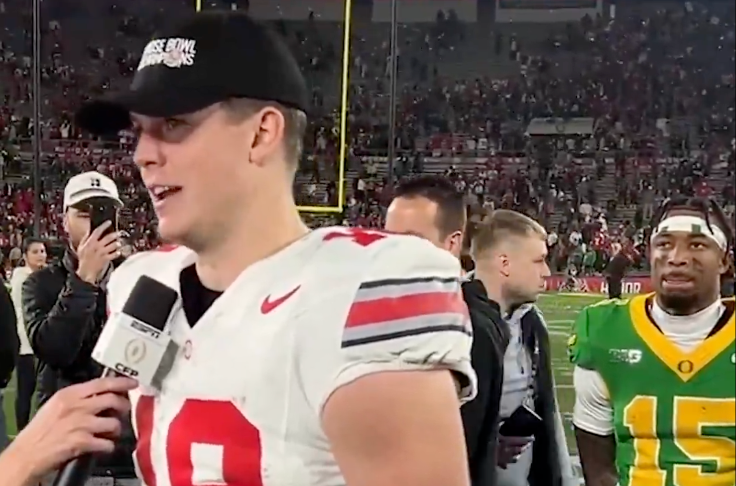 Ohio State QB Will Howard does an interview while Tez Johnson waits to congratulate him on the win
