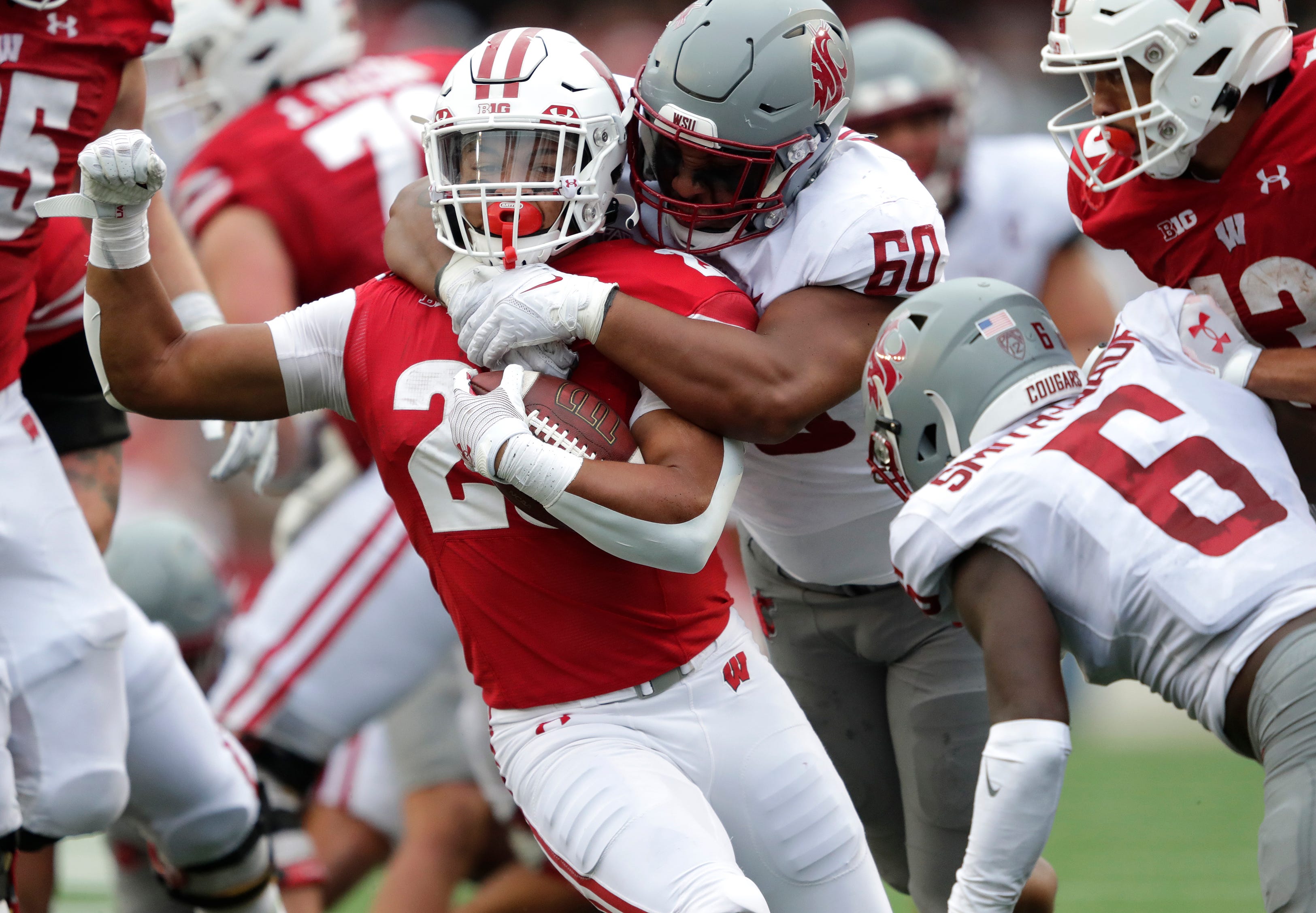Wisconsin Badgers running back Isaac Guerendo (20) is tackled by Washington State Cougars David Gusta (60)during their football game Saturday, September 10, 2022, at Camp Randall in Madison, Wis. 