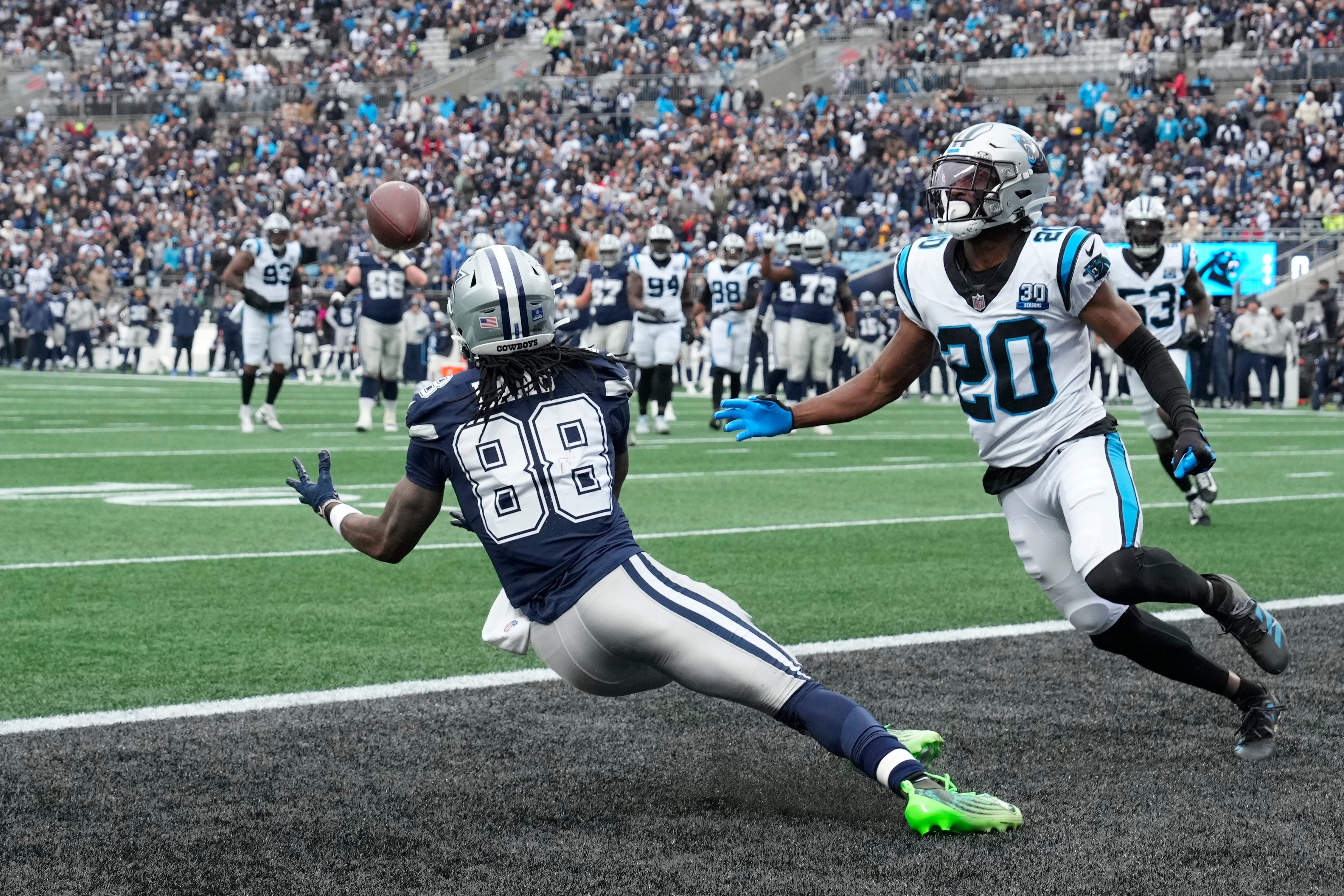 Dec 15, 2024; Charlotte, North Carolina, USA; Dallas Cowboys wide receiver CeeDee Lamb (88) scores a touchdown as Carolina Panthers safety Jordan Fuller (20) defends in the second quarter at Bank of America Stadium.