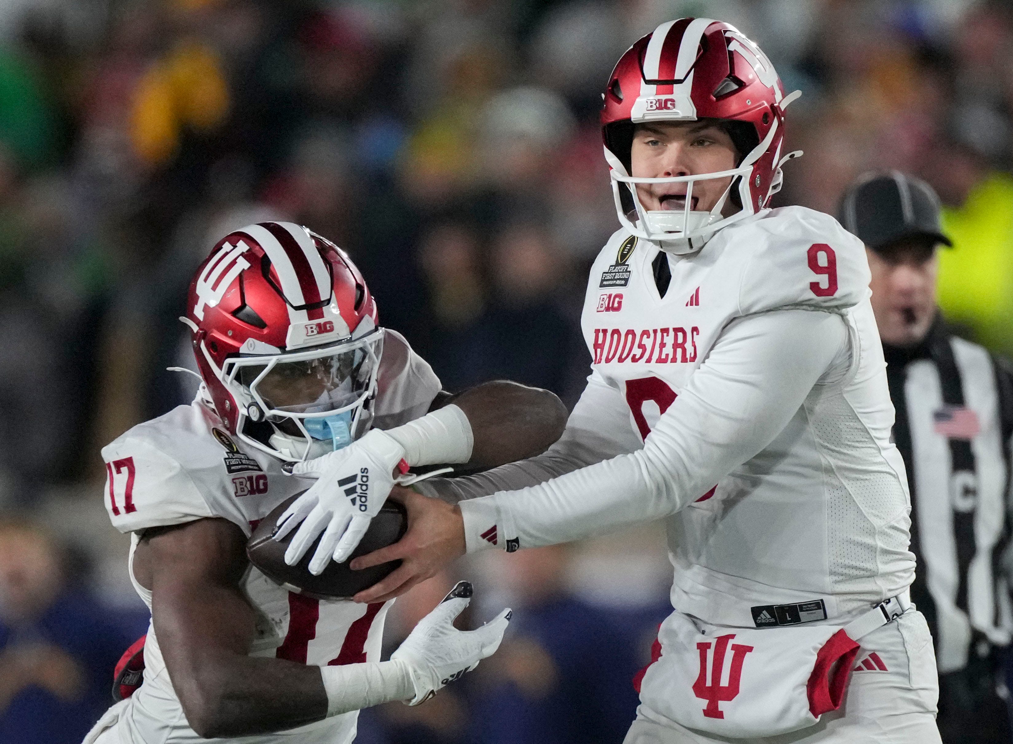 Indiana Hoosiers quarterback Kurtis Rourke (9) hands the ball off to Indiana Hoosiers running back Ty Son Lawton (17) during the first half of a game between the Indiana Hoosiers and the Notre Dame Fighting Irish in first round of the College Football Playoff on Friday, Dec. 20, 2024, in South Bend. Notre Dame defeated Indiana 27-17.