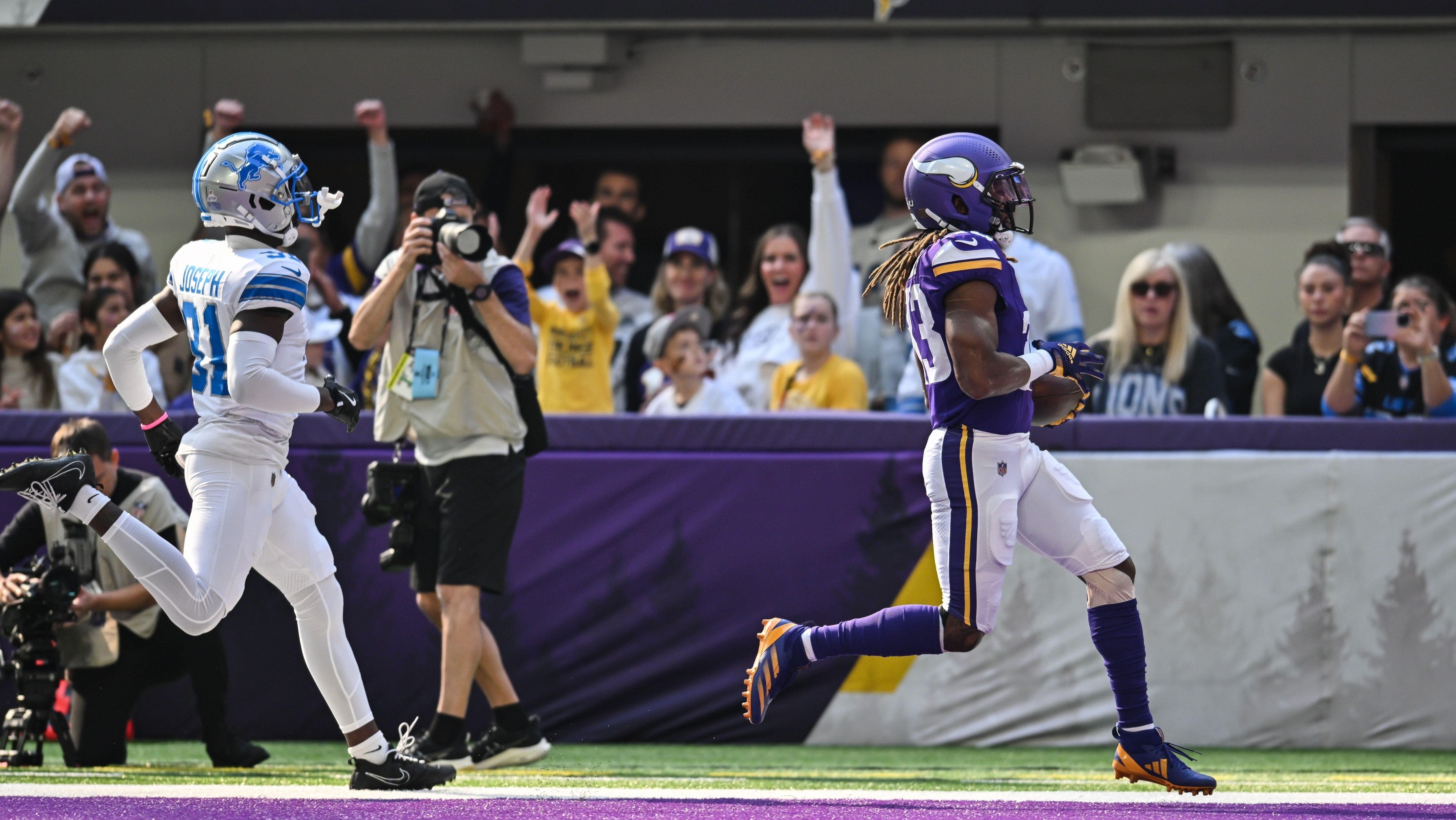 Oct 20, 2024; Minneapolis, Minnesota, USA; Minnesota Vikings running back Aaron Jones (33) scores on a 31 yard touchdown run as Detroit Lions safety Kerby Joseph (31) chases during the first quarter at U.S. Bank Stadium.
