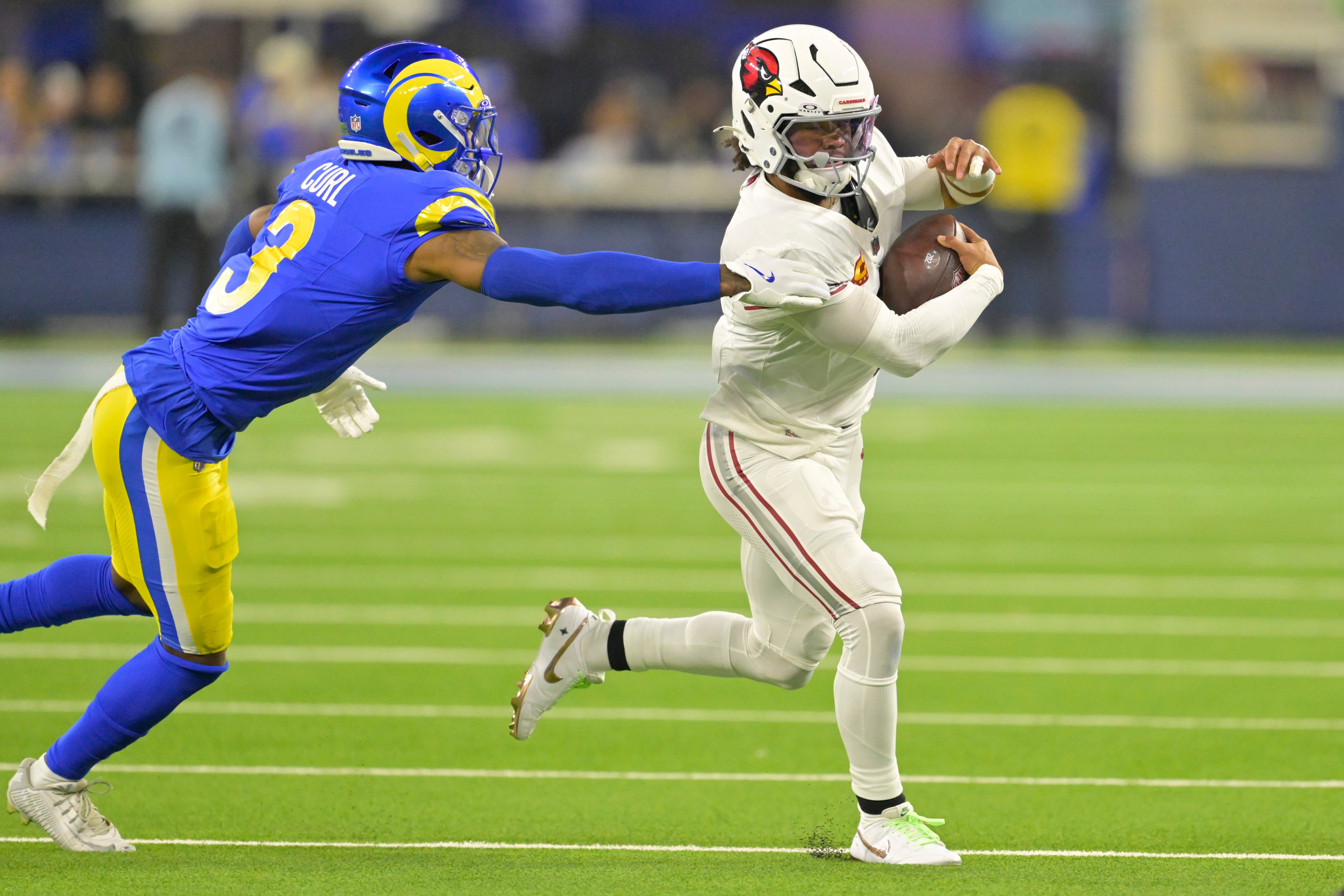 Dec 28, 2024; Inglewood, California, USA; Arizona Cardinals quarterback Kyler Murray (1) is chased down by Los Angeles Rams safety Kamren Curl (3) in the first half at SoFi Stadium.