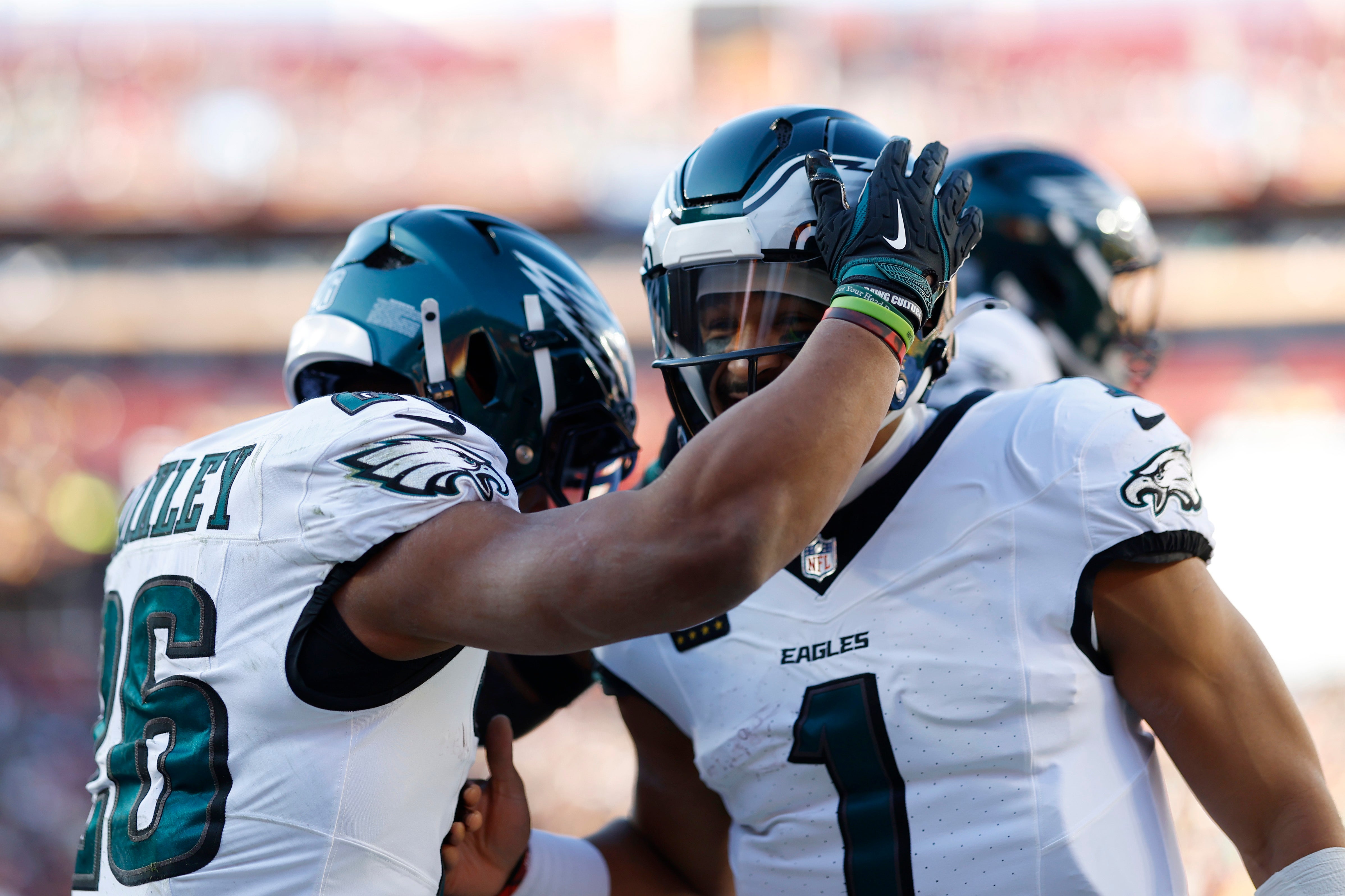 Philadelphia Eagles running back Saquon Barkley (26) celebrates after scoring a touchdown with Eagles quarterback Jalen Hurts (1) against the Washington Commanders during the first quarter.