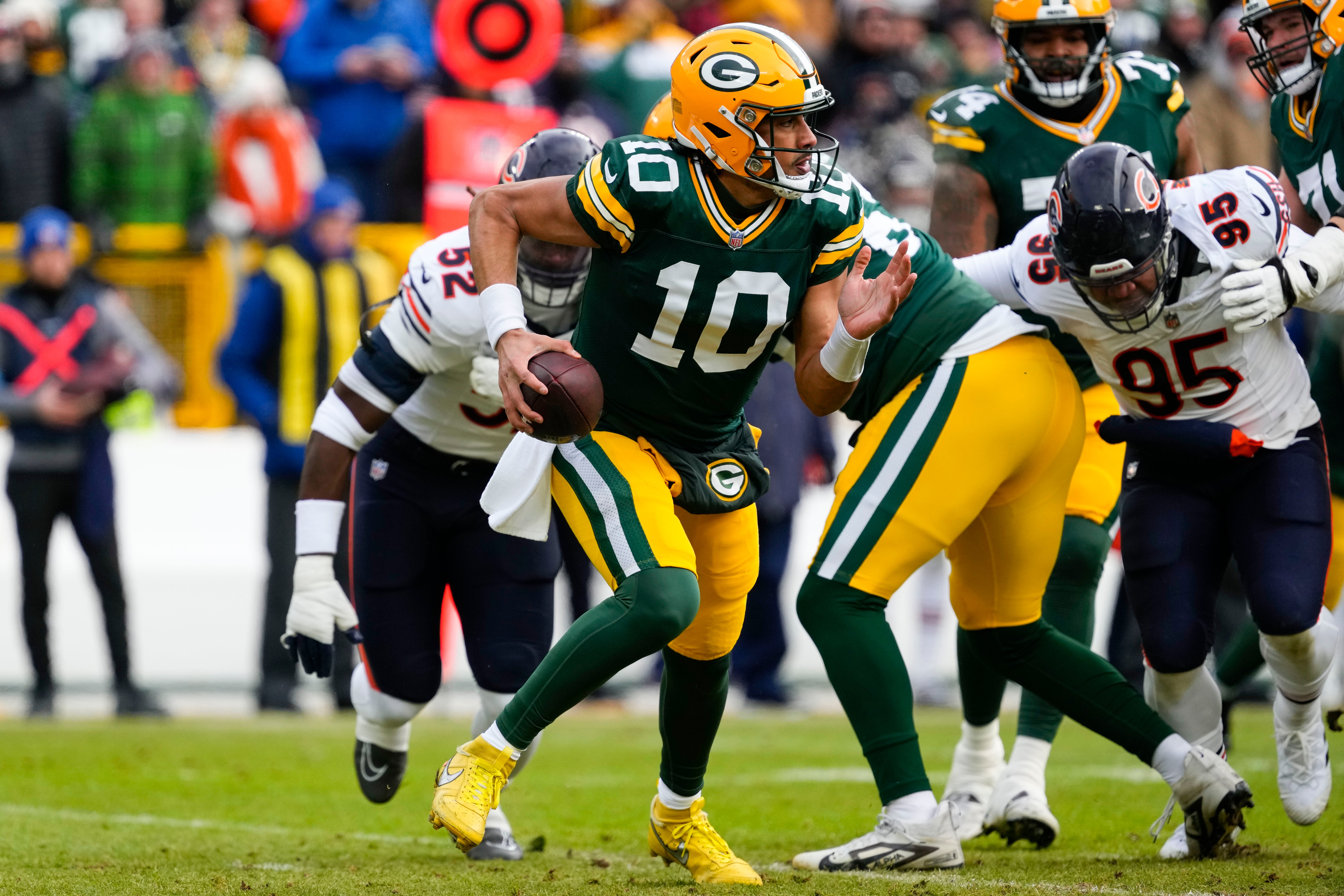 Green Bay Packers quarterback Jordan Love (10) scrambles to avoid pressure during the first quarter against the Chicago Bears at Lambeau Field.