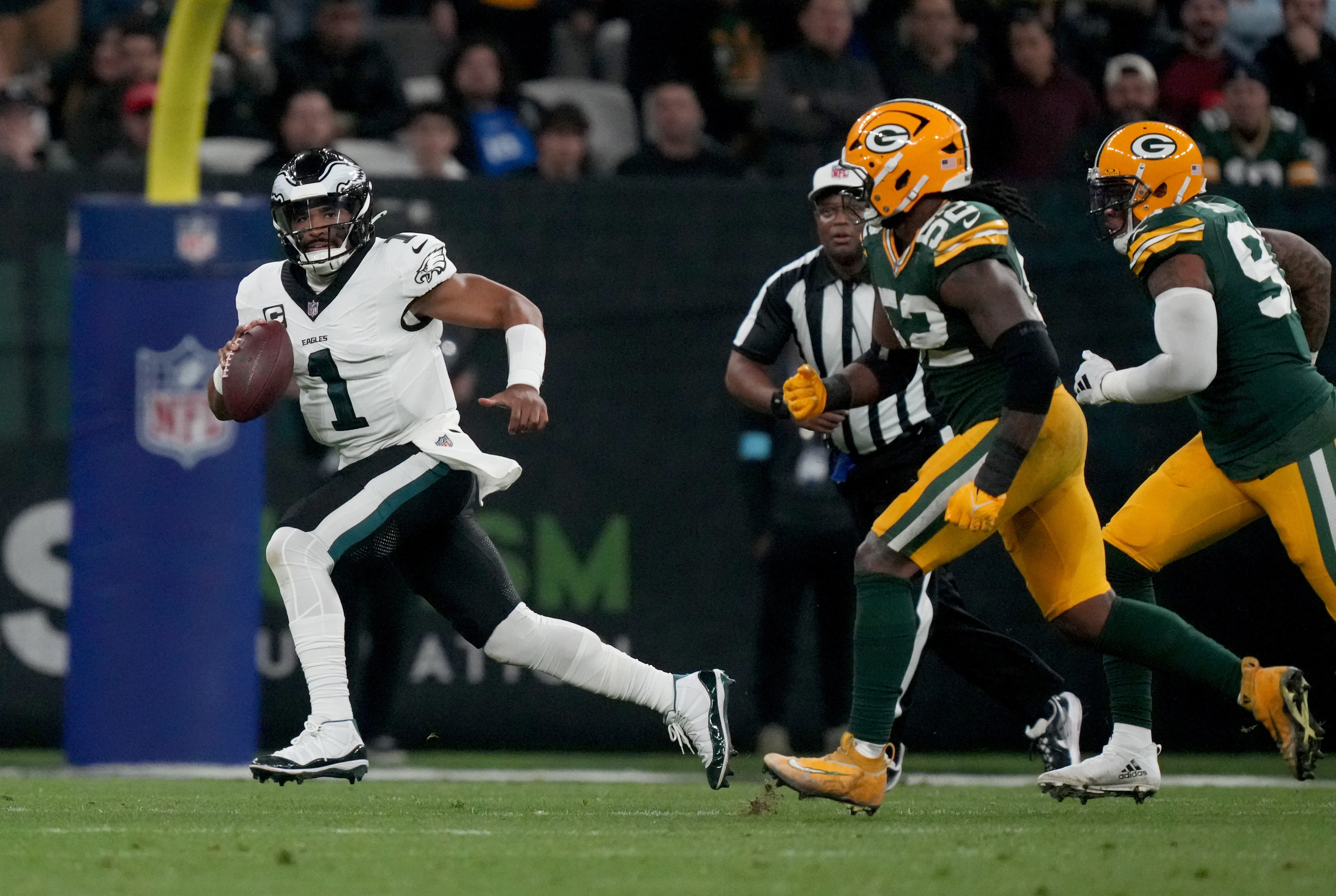 Philadelphia Eagles quarterback Jalen Hurts (1) scrambles against Green Bay Packers defensive end Rashan Gary (52) during the first half at Neo Quimica Arena.