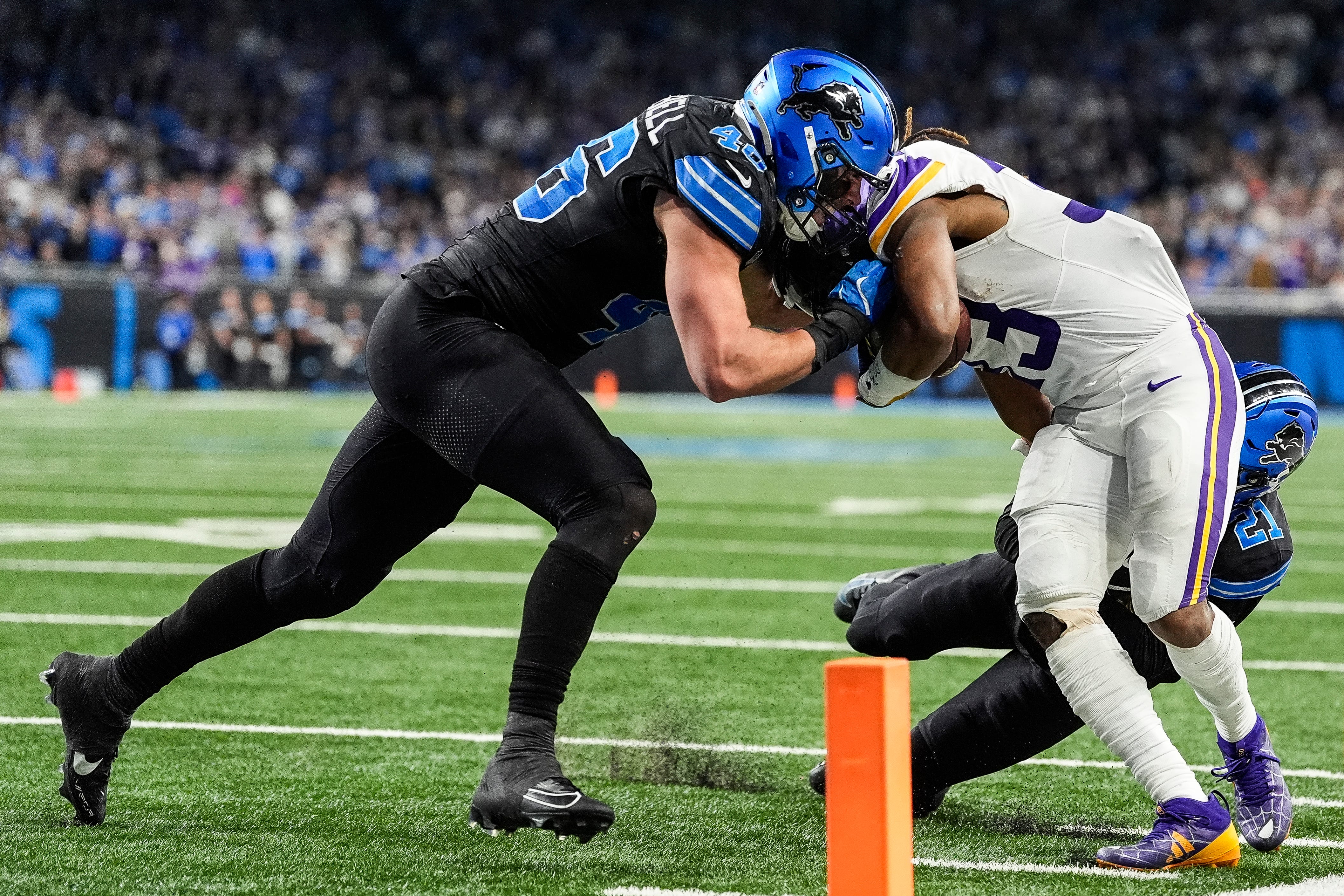 Detroit Lions linebacker Jack Campbell (46), left, and cornerback Amik Robertson (21) tackle Minnesota Vikings running back Aaron Jones (33) during the second half at Ford Field in Detroit on Sunday, Jan. 5, 2025.