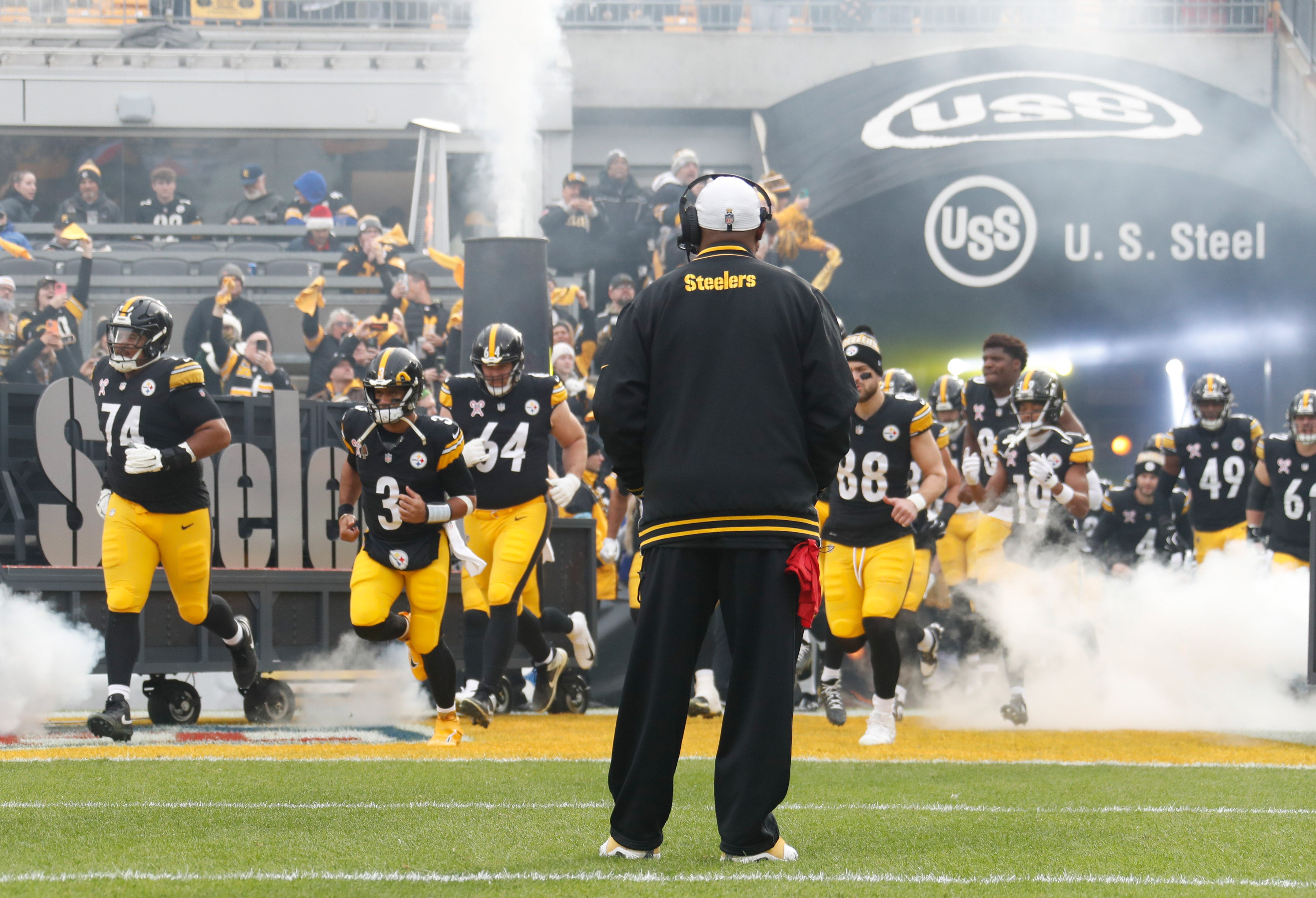 Dec 25, 2024; Pittsburgh, Pennsylvania, USA; The Pittsburgh Steelers take the field as head coach Mike Tomlin (middle) looks on before the game against the Kansas City Chiefs at Acrisure Stadium.