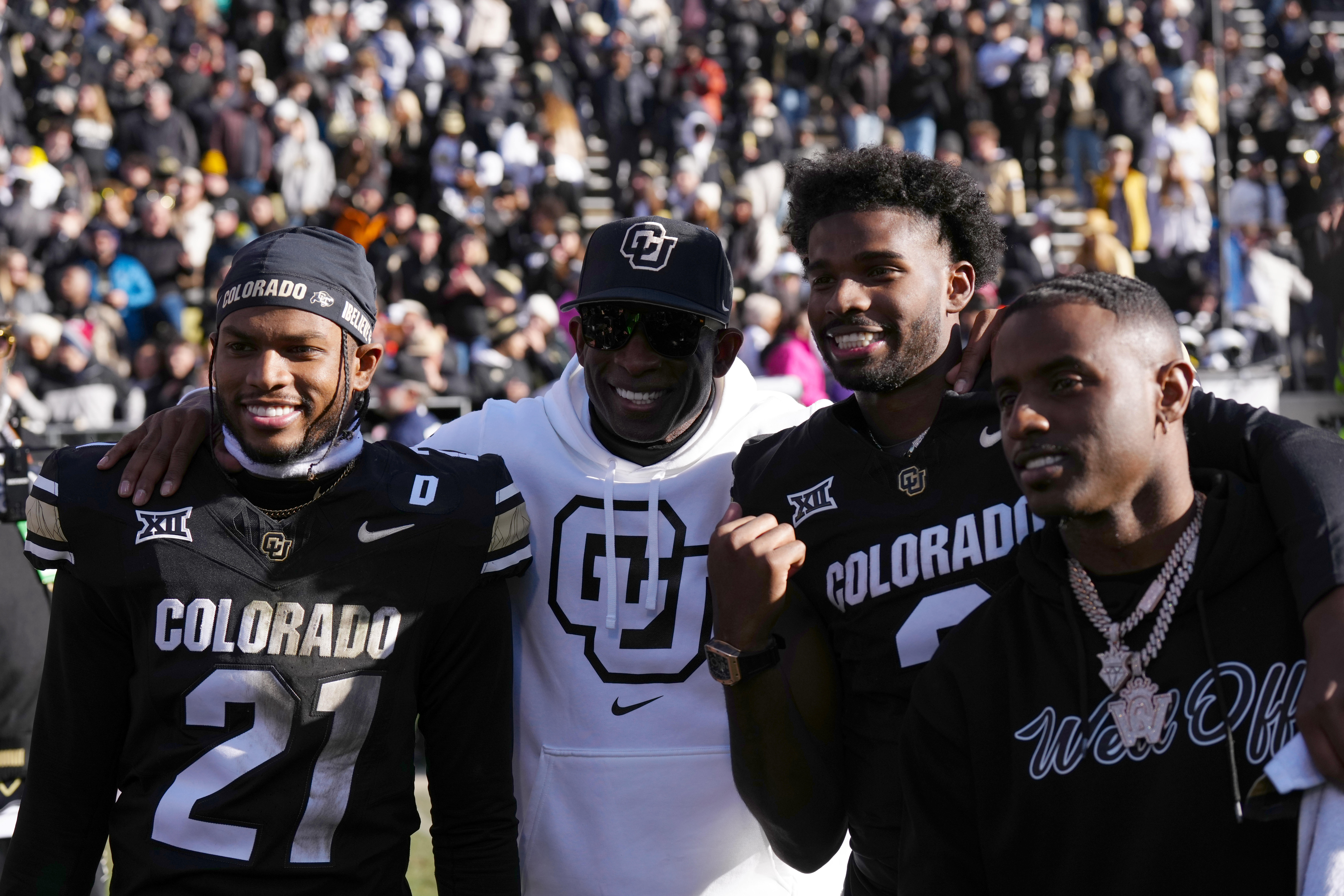 Nov 29, 2024; Boulder, Colorado, USA; Colorado Buffaloes safety Shilo Sanders (21) and head coach Deion Sanders and quarterback Shedeur Sanders (2) and social media producer Deion Sanders Jr. following the win against the Oklahoma State Cowboys at Folsom Field.