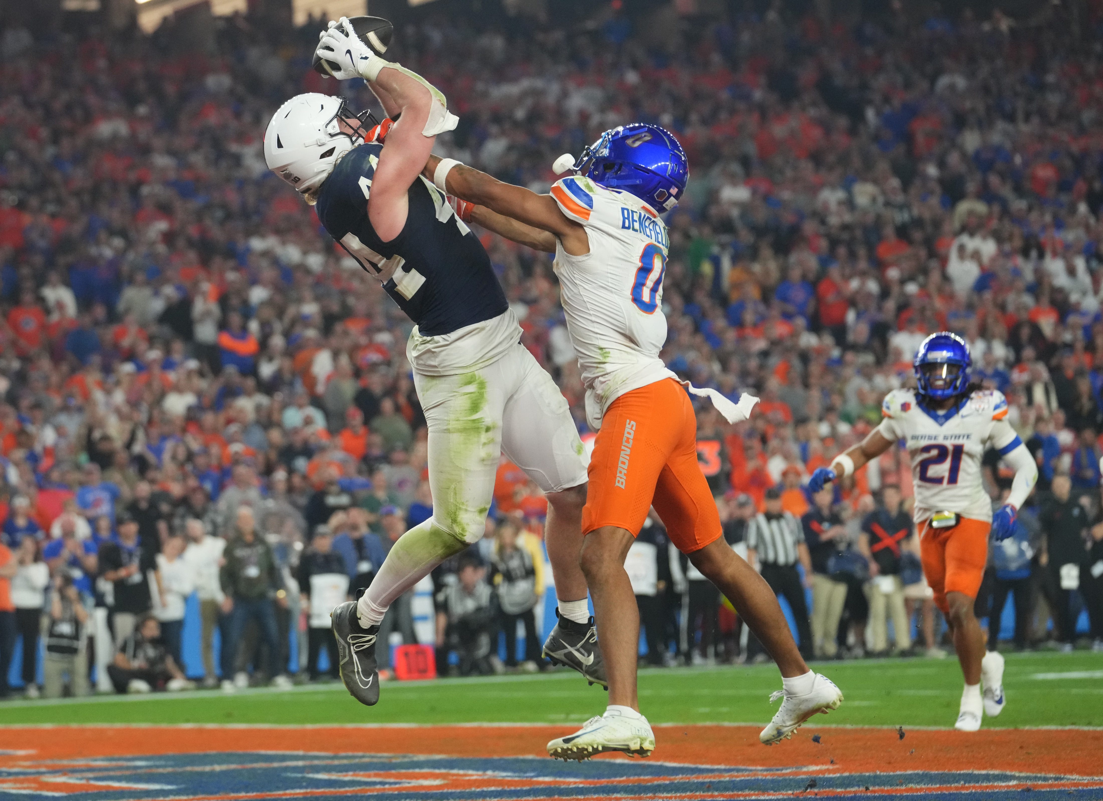 Penn State Nittany Lions tight end Tyler Warren (44) catches a touchdown pass over Boise State Broncos safety Ty Benefield (0) during their Vrbo Fiesta Bowl matchup at State Farm Stadium.
