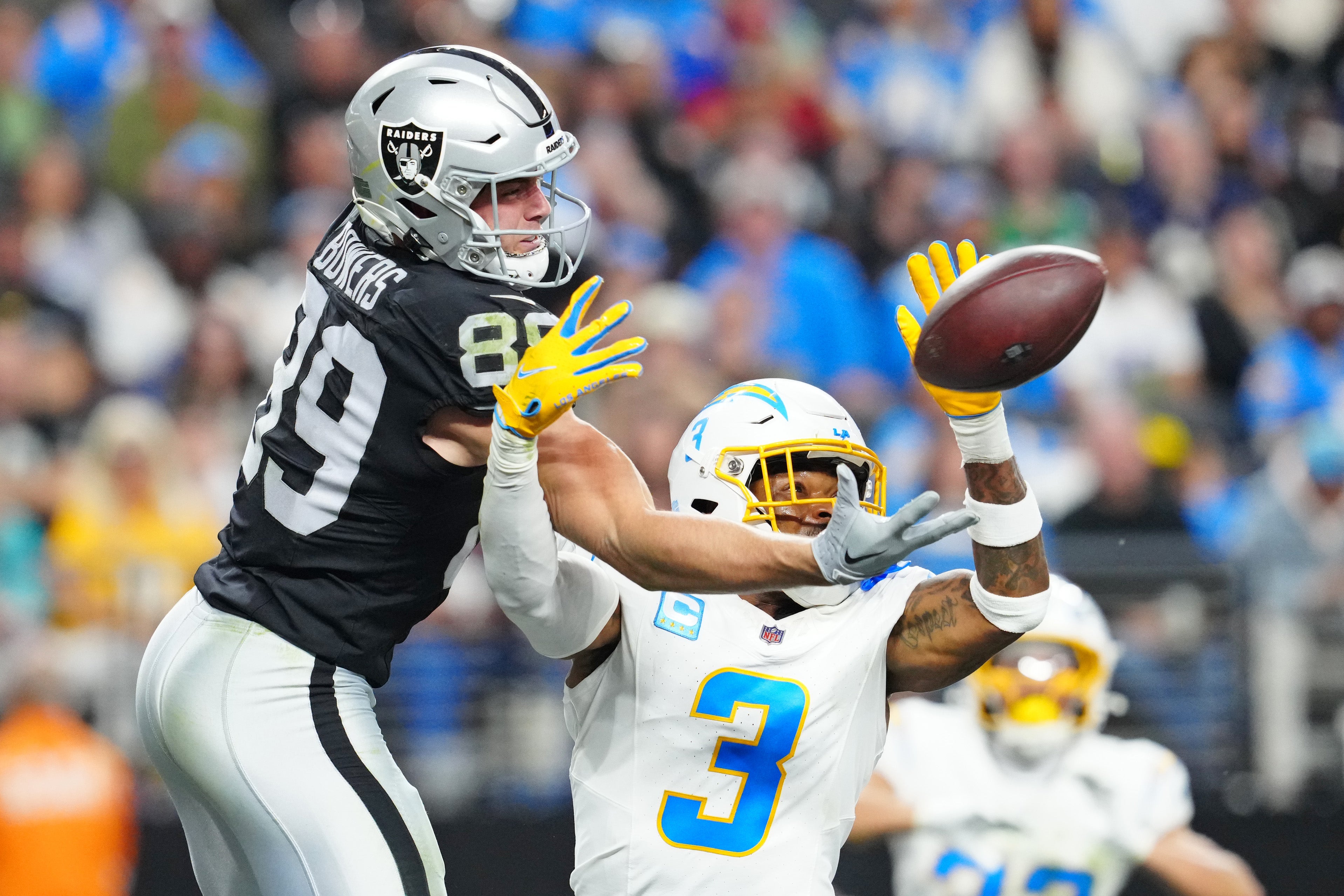 Chargers safety Derwin James deflects a pass against Raiders tight end Brock Bowers.