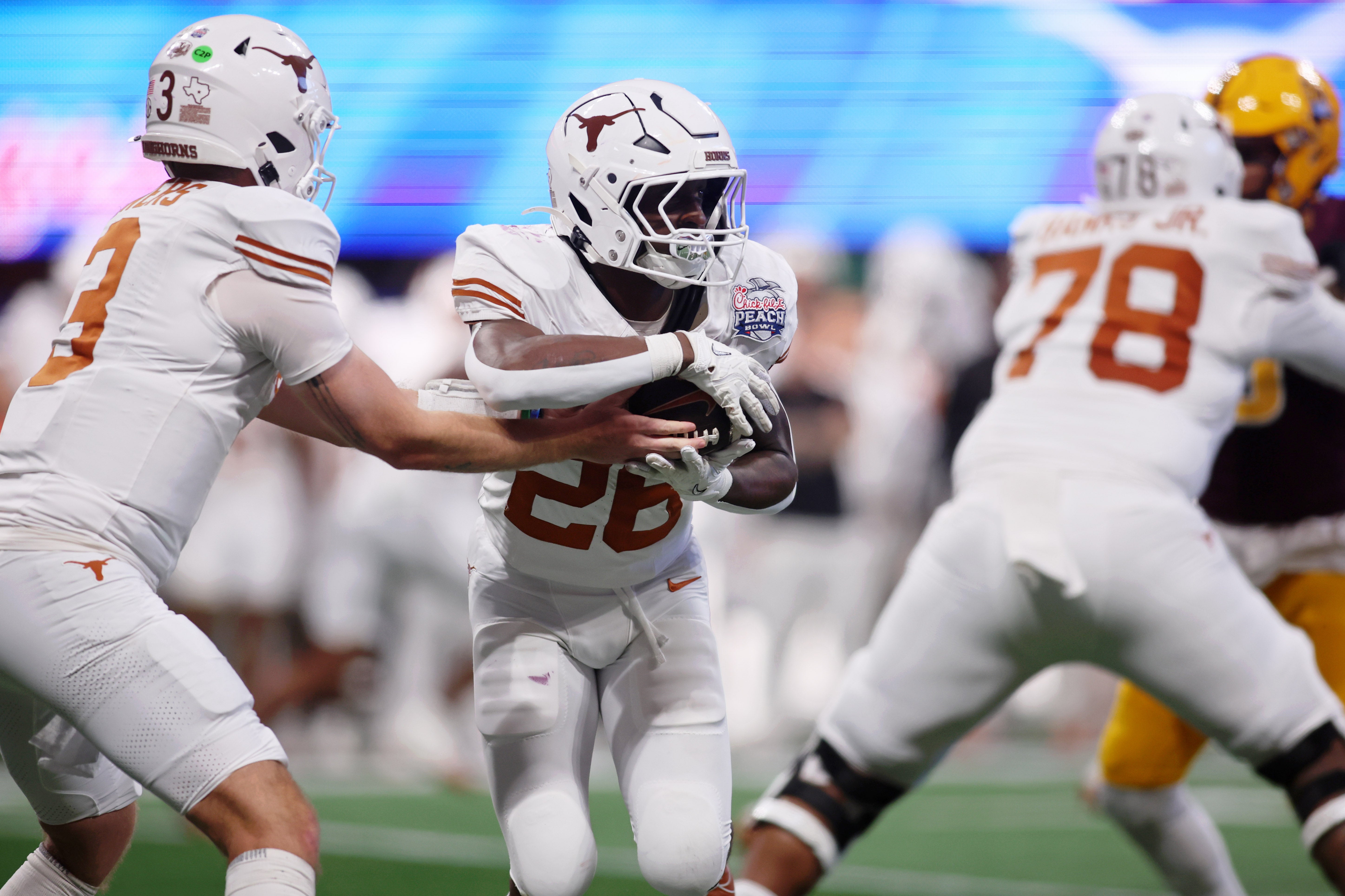 Jan 1, 2025; Atlanta, GA, USA; Texas Longhorns quarterback Quinn Ewers (3) fakes a handoff to running back Quintrevion Wisner (26) against the Arizona State Sun Devils during the second half of the Peach Bowl at Mercedes-Benz Stadium.