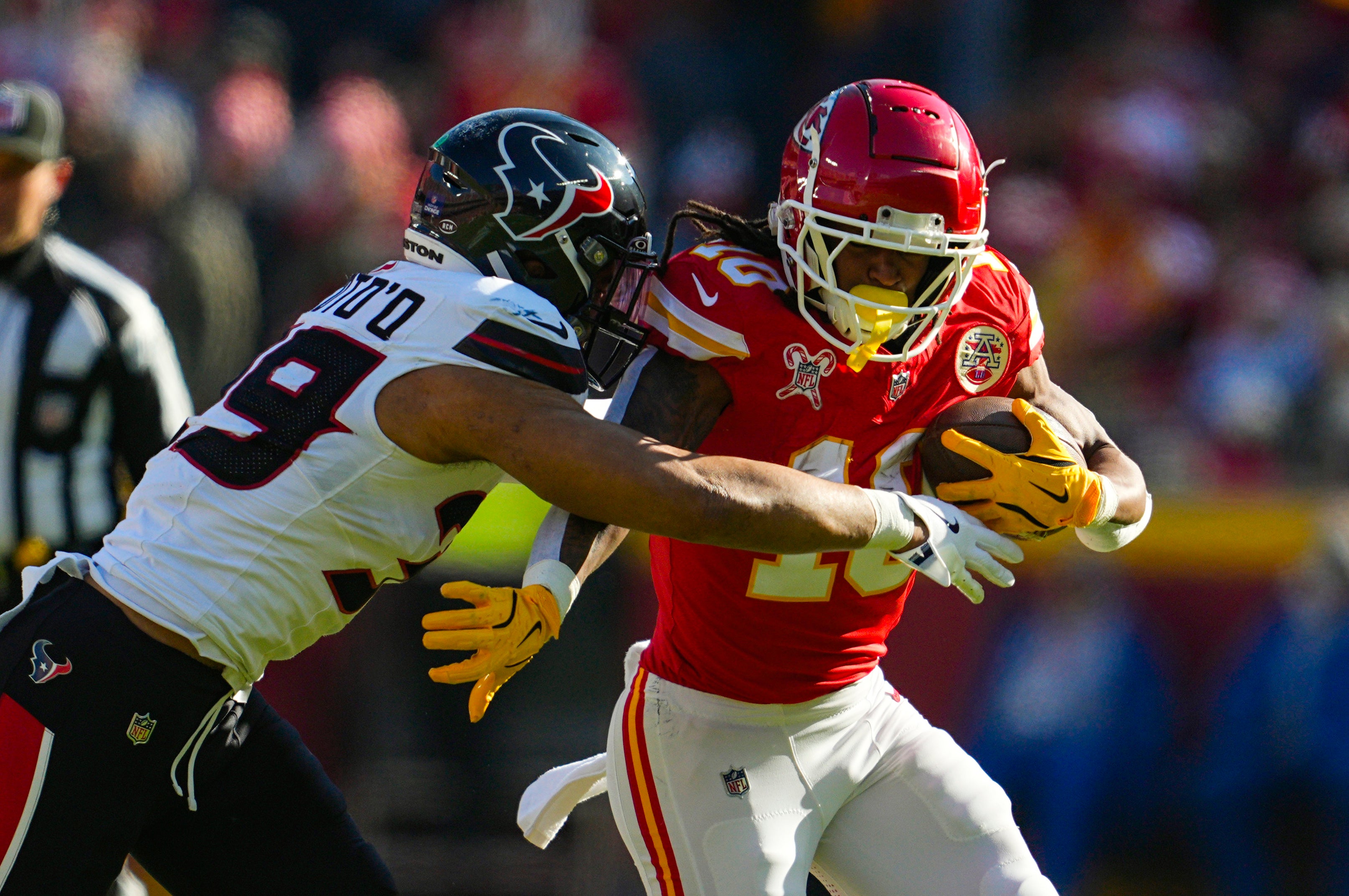 Dec 21, 2024; Kansas City, Missouri, USA; Kansas City Chiefs running back Isiah Pacheco (10) runs the ball against Houston Texans linebacker Henry To'oTo'o (39) during the first half at GEHA Field at Arrowhead Stadium.