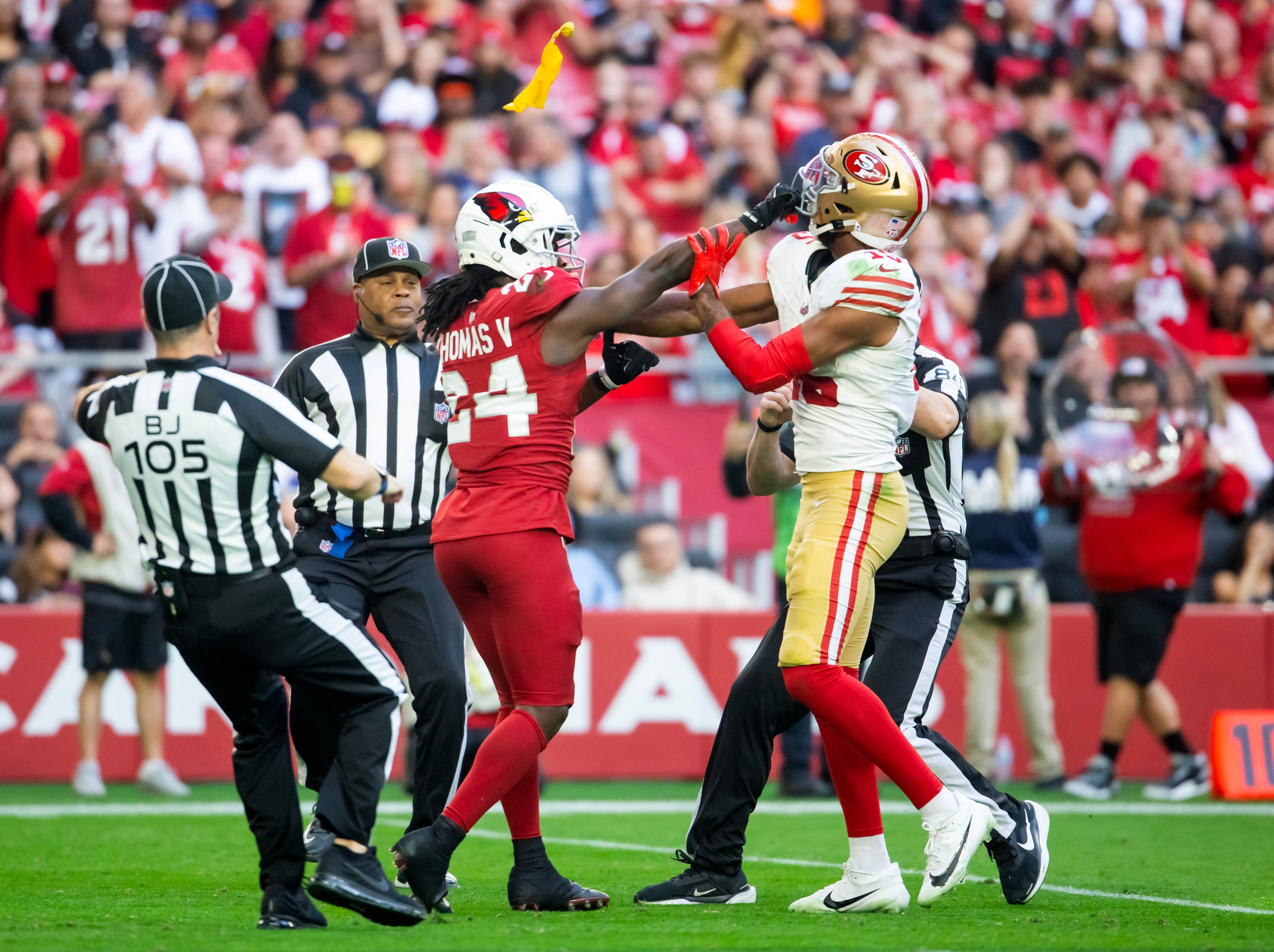 Referees throw yellow penalty flags as San Francisco 49ers wide receiver Jauan Jennings (15) fights Arizona Cardinals cornerback Starling Thomas V (24) in the first half at State Farm Stadium.