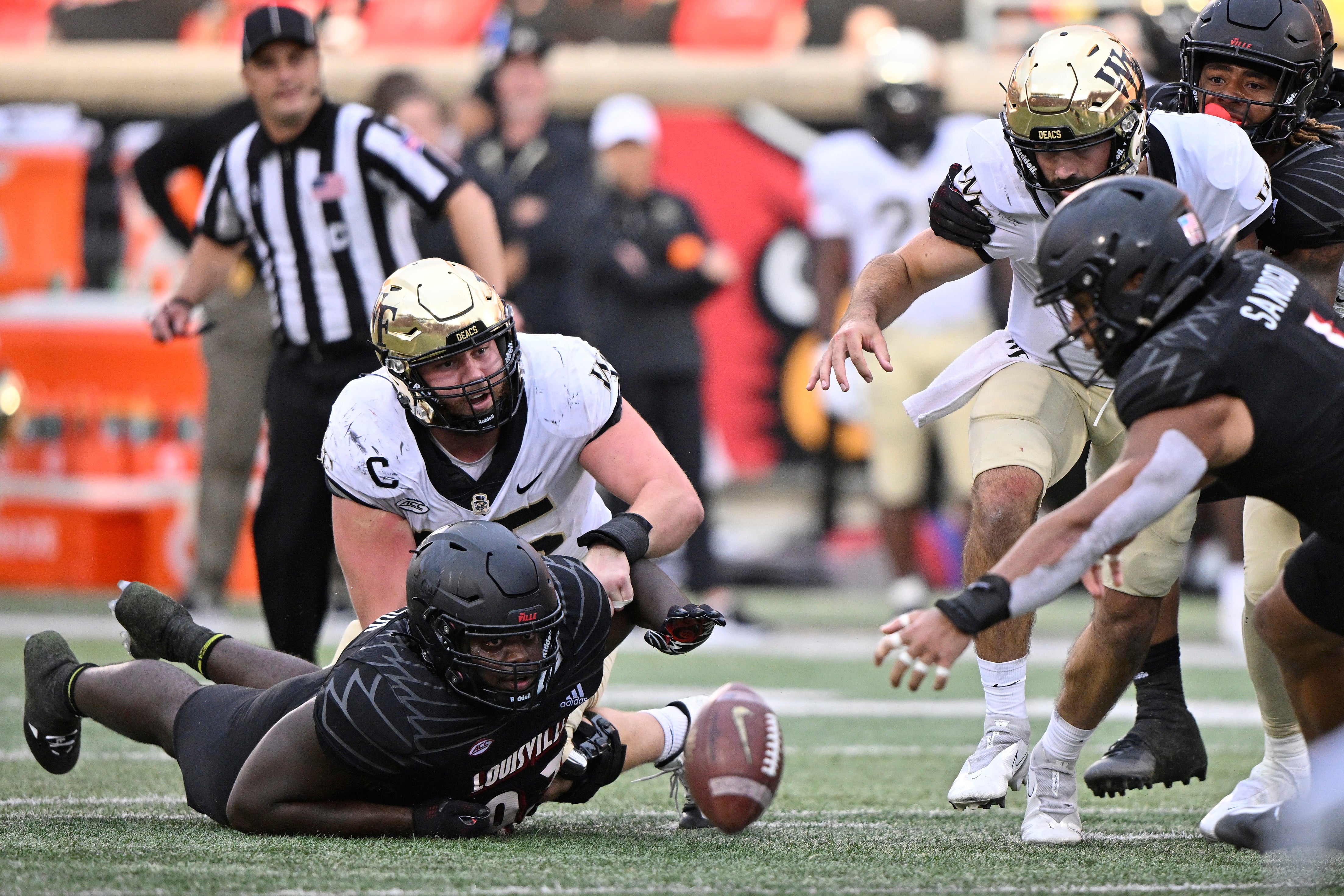 Louisville Cardinals defensive lineman Jared Dawson (93) scrambles to recover the ball after forcing Wake Forest Demon Deacons quarterback Sam Hartman (10) to fumble during the second half at Cardinal Stadium. Louisville won 48-21.