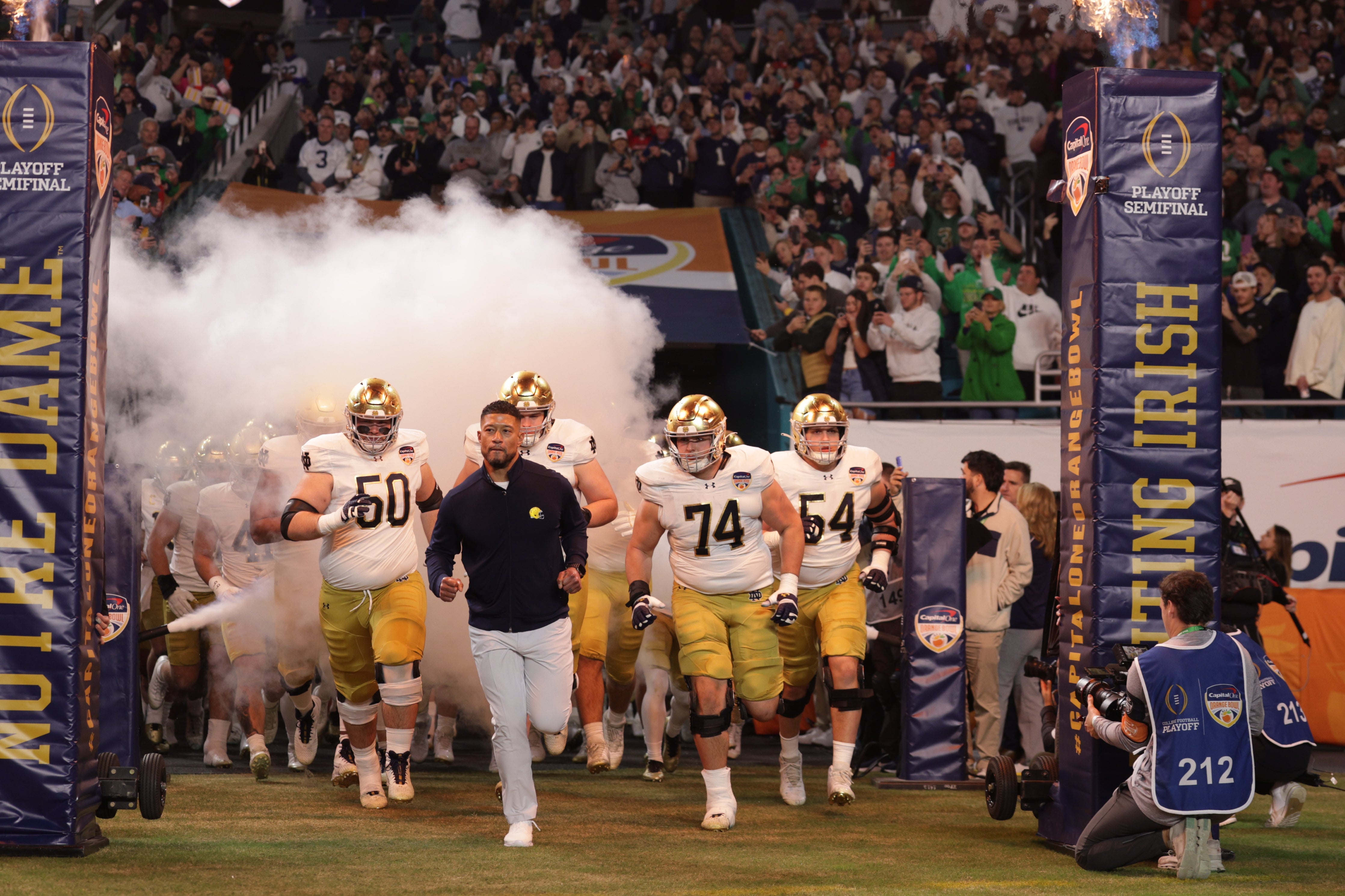 Notre Dame Fighting Irish head coach Marcus Freeman leads the team onto the field before the game against the Penn State Nittany Lions in the Orange Bowl at Hard Rock Stadium.