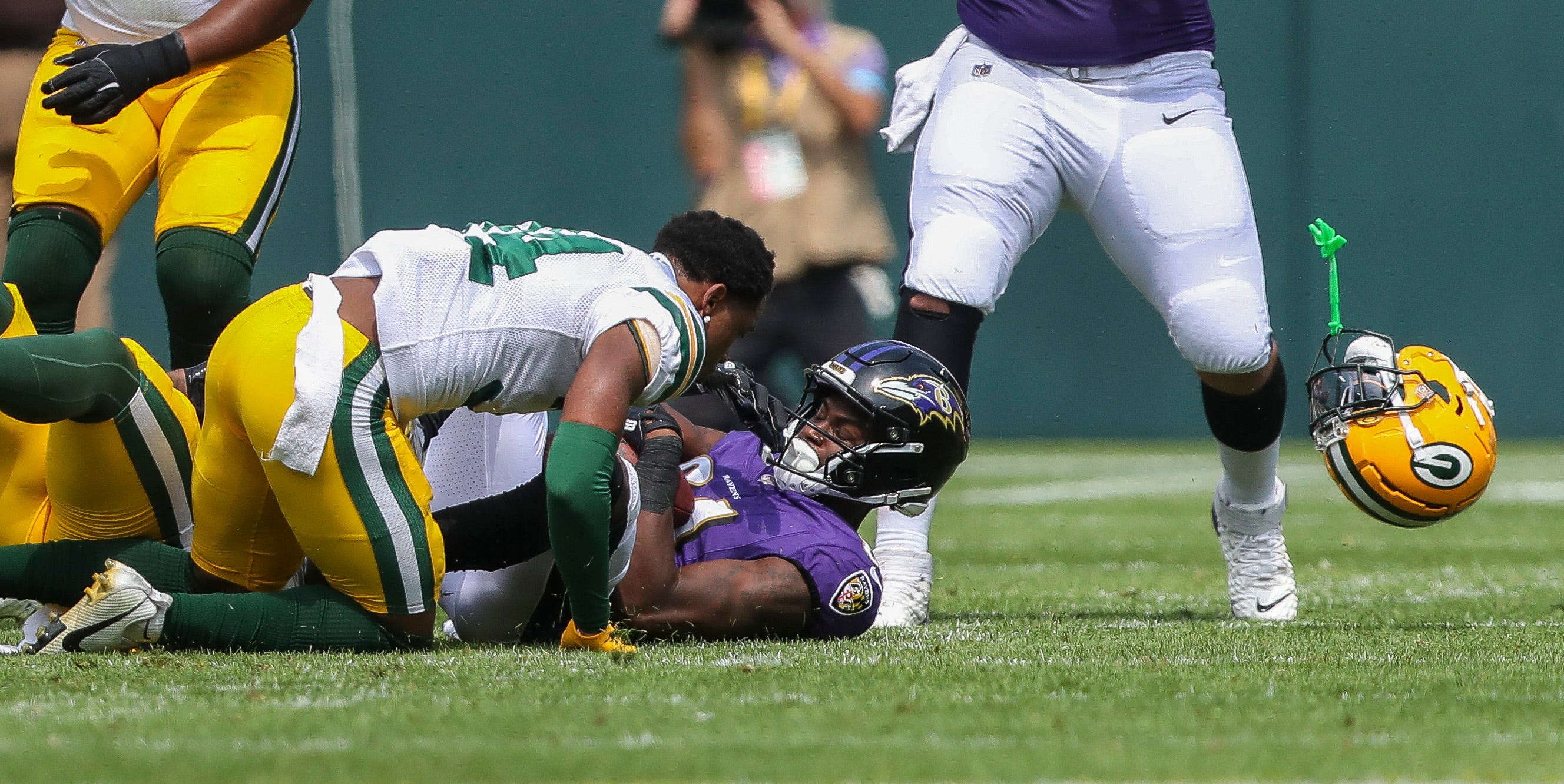Green Bay Packers cornerback Kalen King (34) loses his helmet as he tackles Baltimore Ravens wide receiver Devontez Walker (81) during an NFL preseason game on Saturday, August 24, 2024, at Lambeau Field in Green Bay, Wis.
