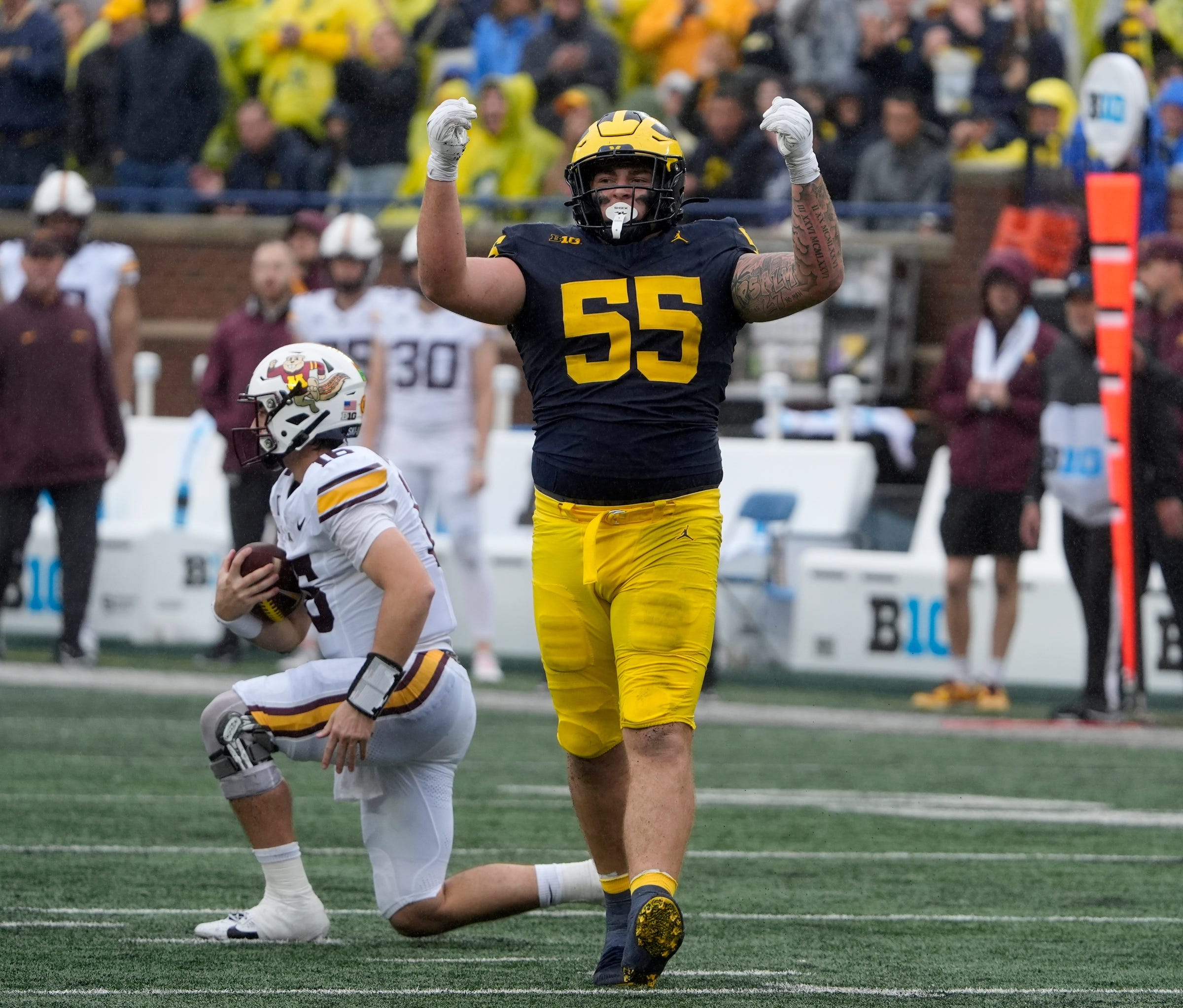 Michigan defensive lineman Mason Graham celebrates after sacking Minnesota quarterback Max Brosmer, in the background, during first-half action between Michigan and Minnesota at Michigan Stadium in Ann Arbor on Saturday, Sept. 28, 2024.