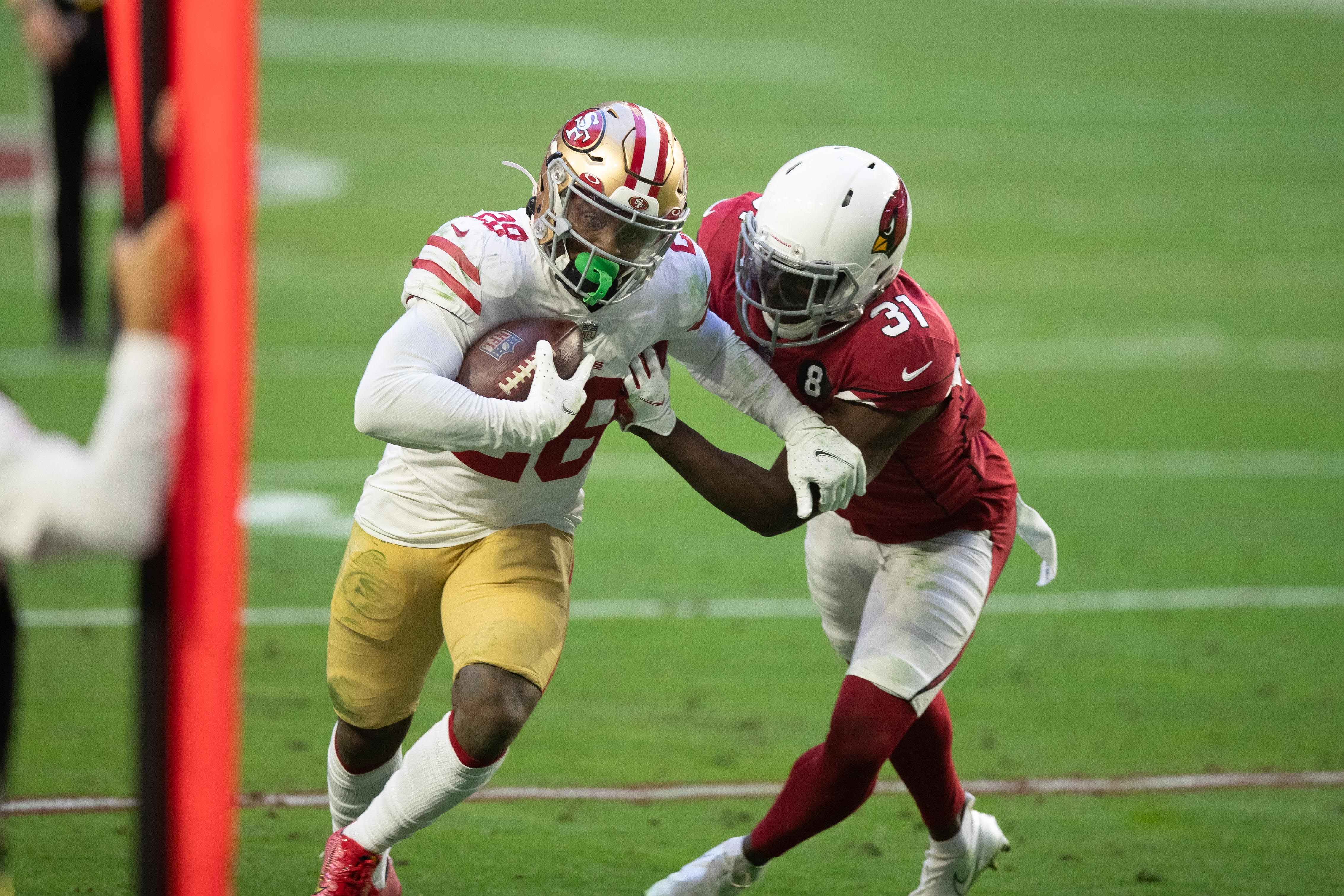 San Francisco 49ers running back Jerick McKinnon (28) runs the ball against Arizona Cardinals free safety Chris Banjo (31) in the third quarter at State Farm Stadium.