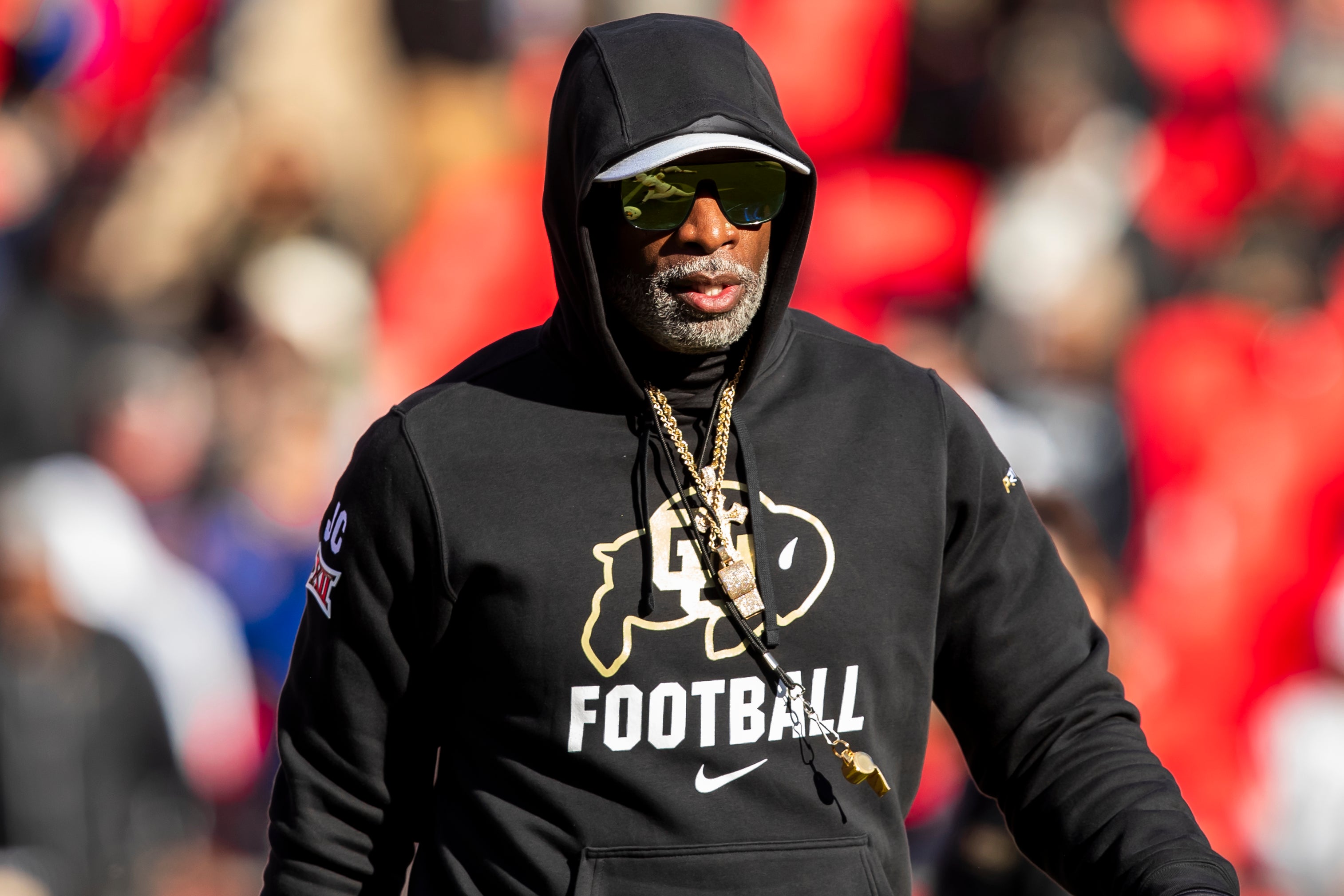 Colorado head coach Deion Sanders watches his players warmup prior to the game between the Kansas Jayhawks and the Colorado Buffaloes at GEHA Field at Arrowhead Stadium.
