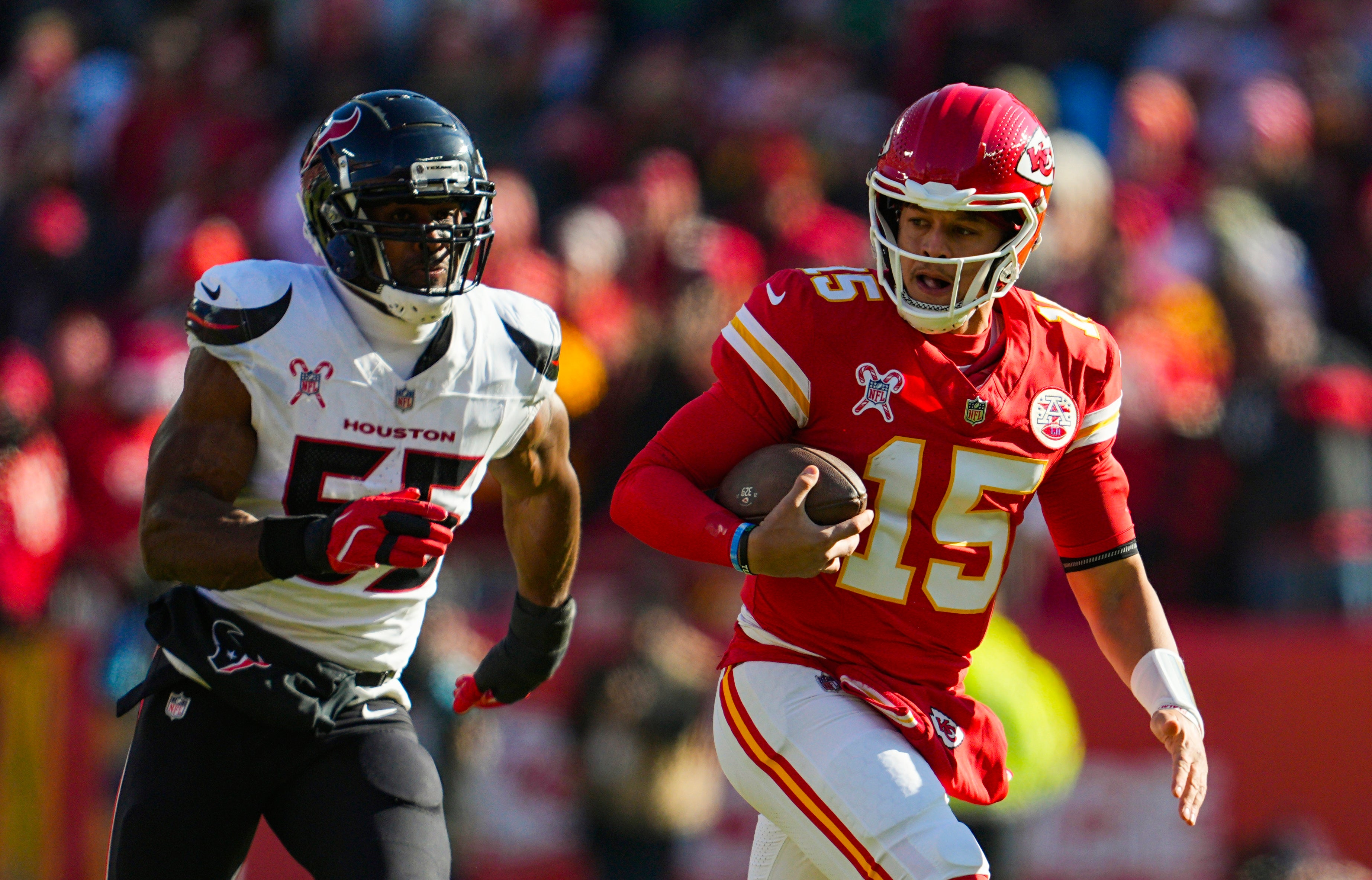 Chiefs quarterback Patrick Mahomes (15) runs the ball against Texans defensive end Danielle Hunter (55)