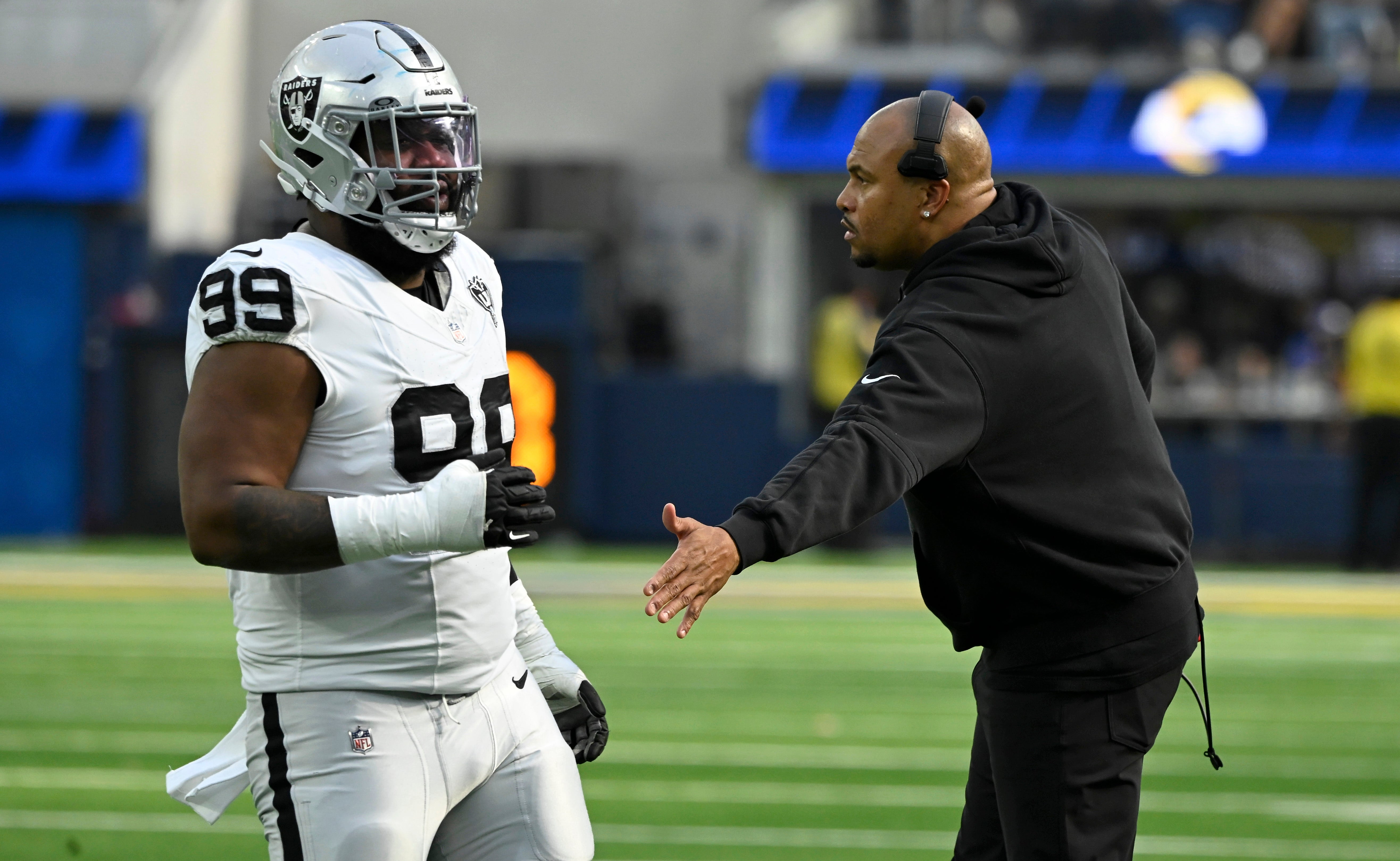 Las Vegas Raiders head coach Antonio Pierce and Las Vegas Raiders defensive tackle Nesta Jade Silvera (99) during the third quarter against the Los Angeles Rams at SoFi Stadium.