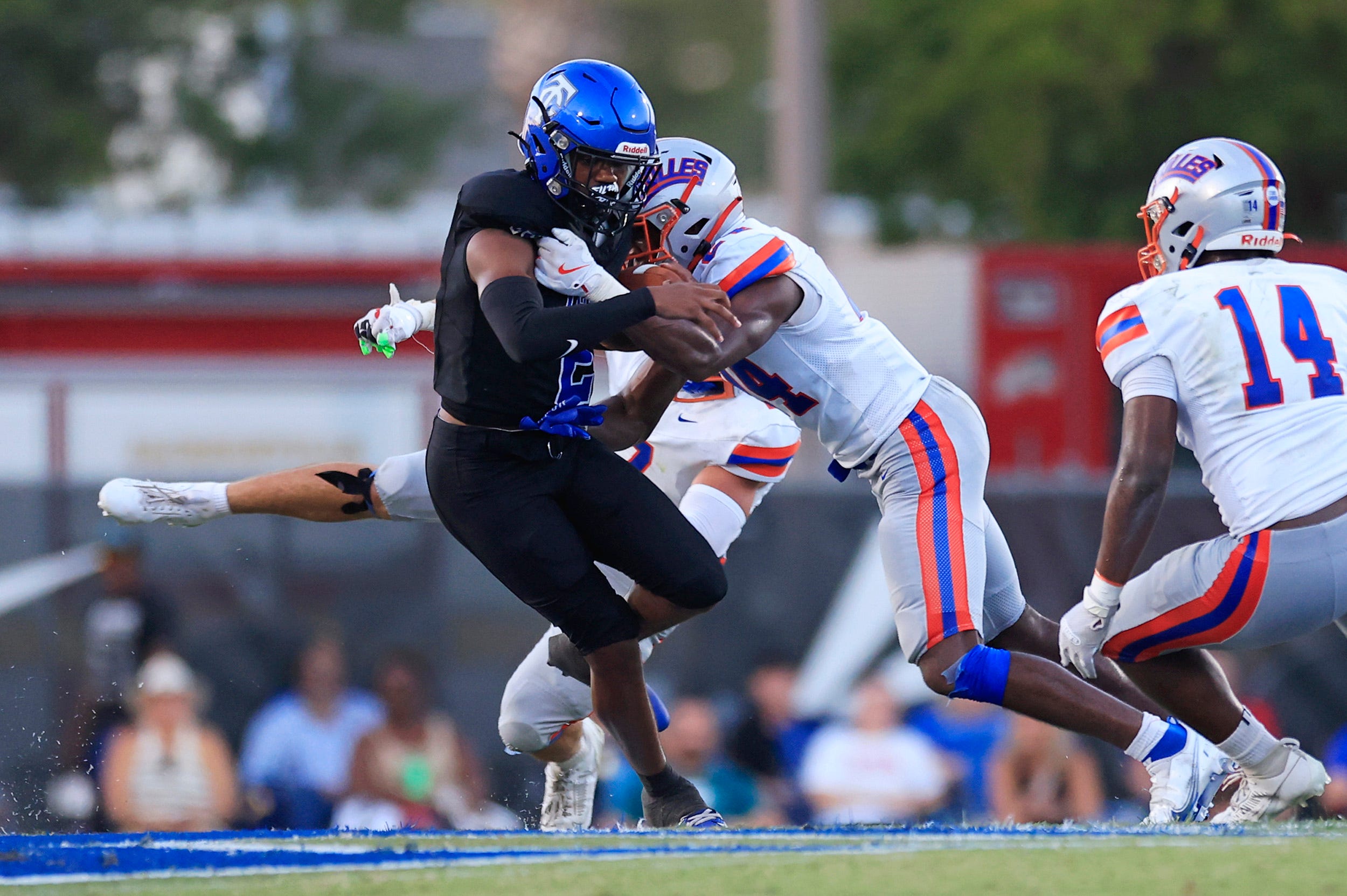 Trinity Christian's Terel Dallas (2) is tackled by Bolles' Simeon Caldwell (24) and Troy Holloway (7), back, pressuring during the second quarter of a high school football matchup Friday, Aug. 30, 2024 at Trinity Christian Academy in Jacksonville, Fla. The Bolles Bulldogs defeated the Trinity Christian Conquerors 41-7.