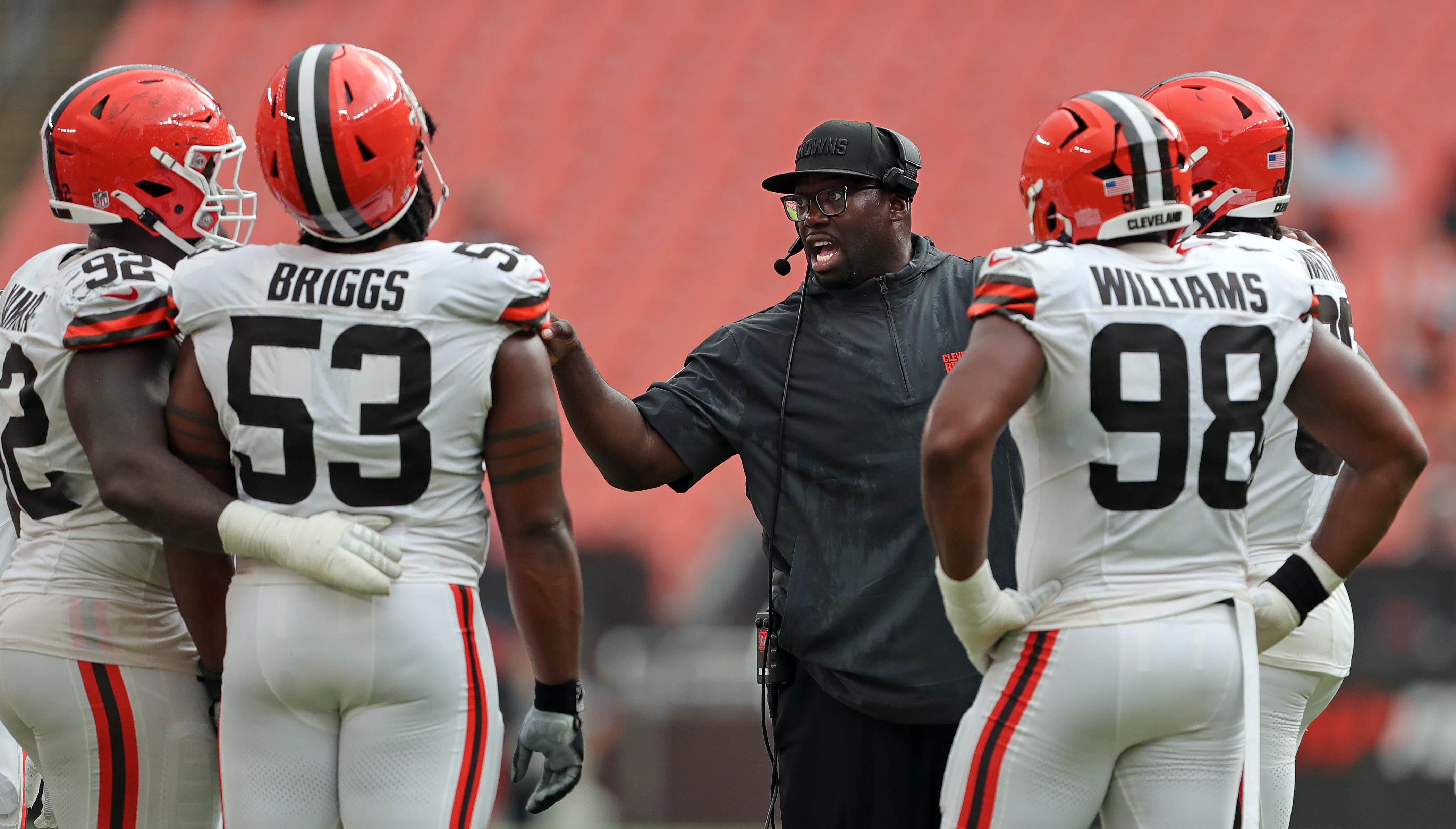Cleveland Browns defensive line coach Jacques Cesaire, center, has a word with his linemen during the second half of an NFL preseason football game at Cleveland Browns Stadium, Saturday, Aug. 17, 2024, in Cleveland, Ohio.