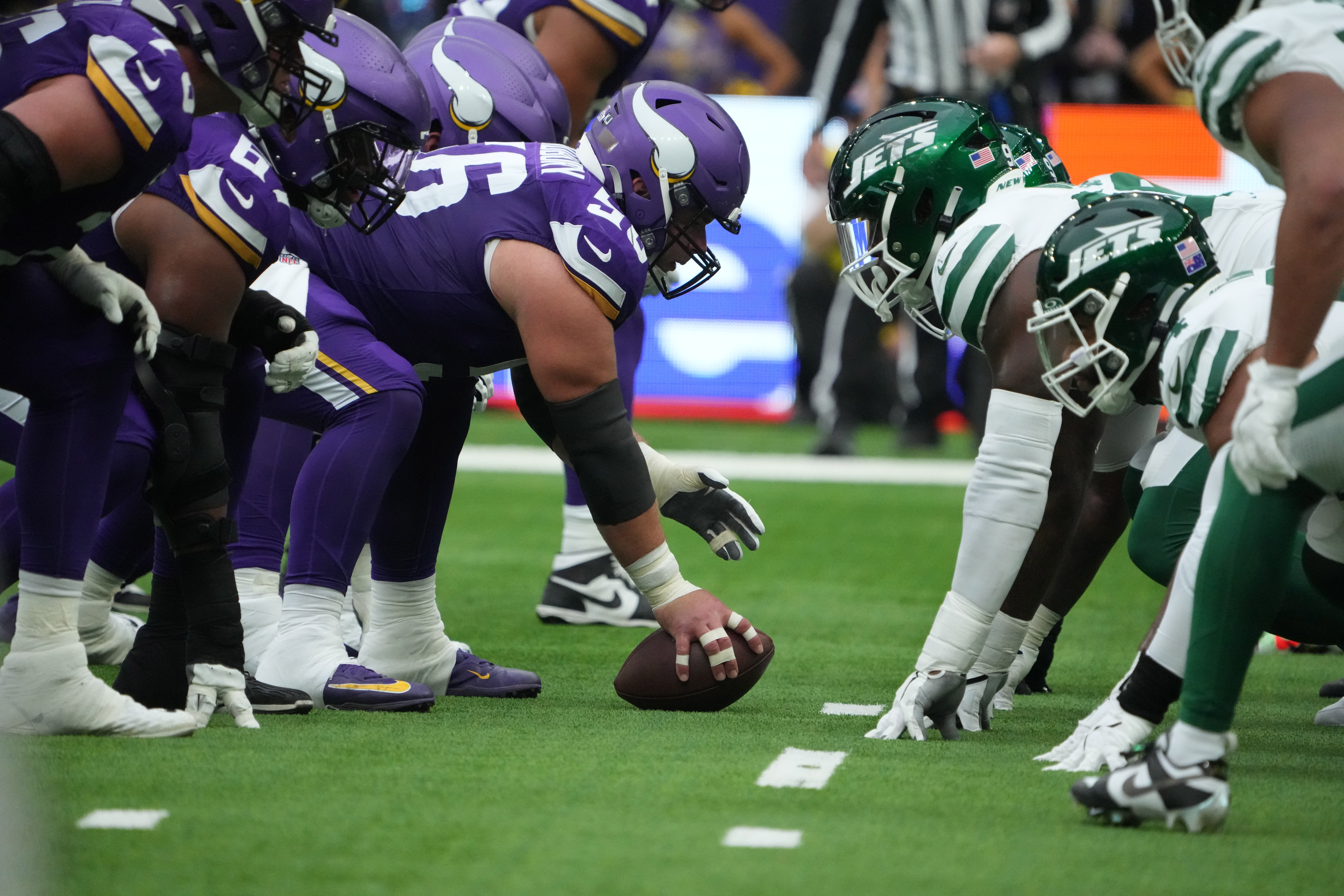 Oct 6, 2024; London, United Kingdom; Helmets at the line of scrimmage as Minnesota Vikings center Garrett Bradbury (56) snaps the ball against the New York Jets at Tottenham Hotspur Stadium.