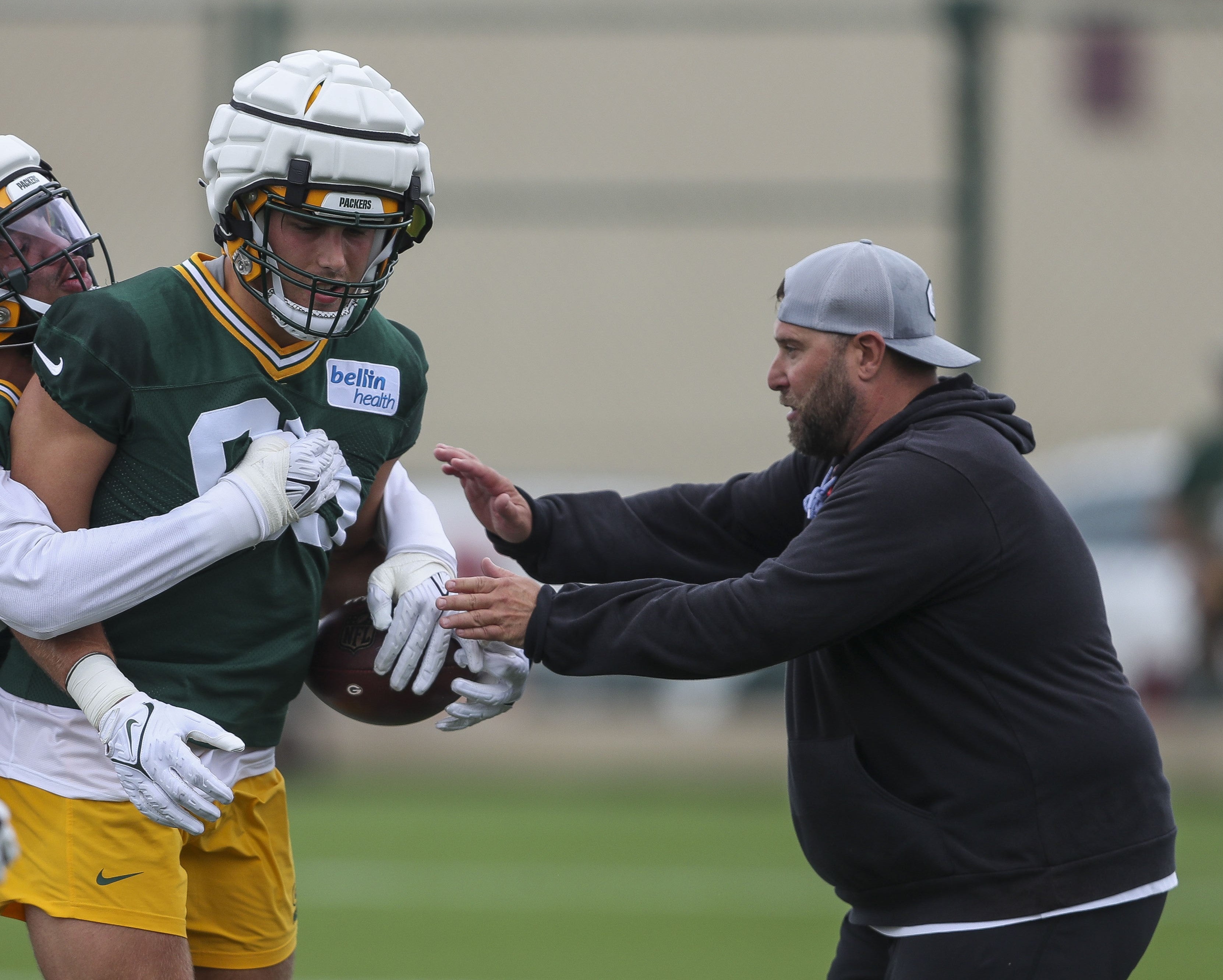 July 26, 2023; Green Bay, WI, USA; Green Bay Packers linebackers Keshawn Banks (left) and Lukas Van Ness (center) run through positional drills with pass rush specialist Jason Rebrovich (right) during the first day of practice at training camp at Ray Nitschke Field.